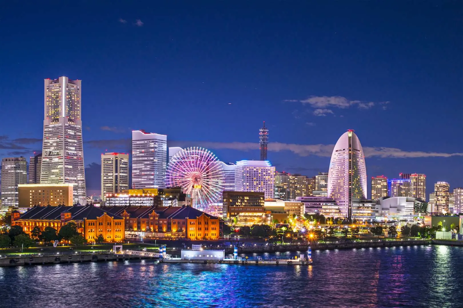 横浜みなとみらいのきらめく夜景。高層ビル群と輝く観覧車が壮大な景観を創り出し、東急線・みなとみらい線パスでの旅の完璧な締めくくり。
