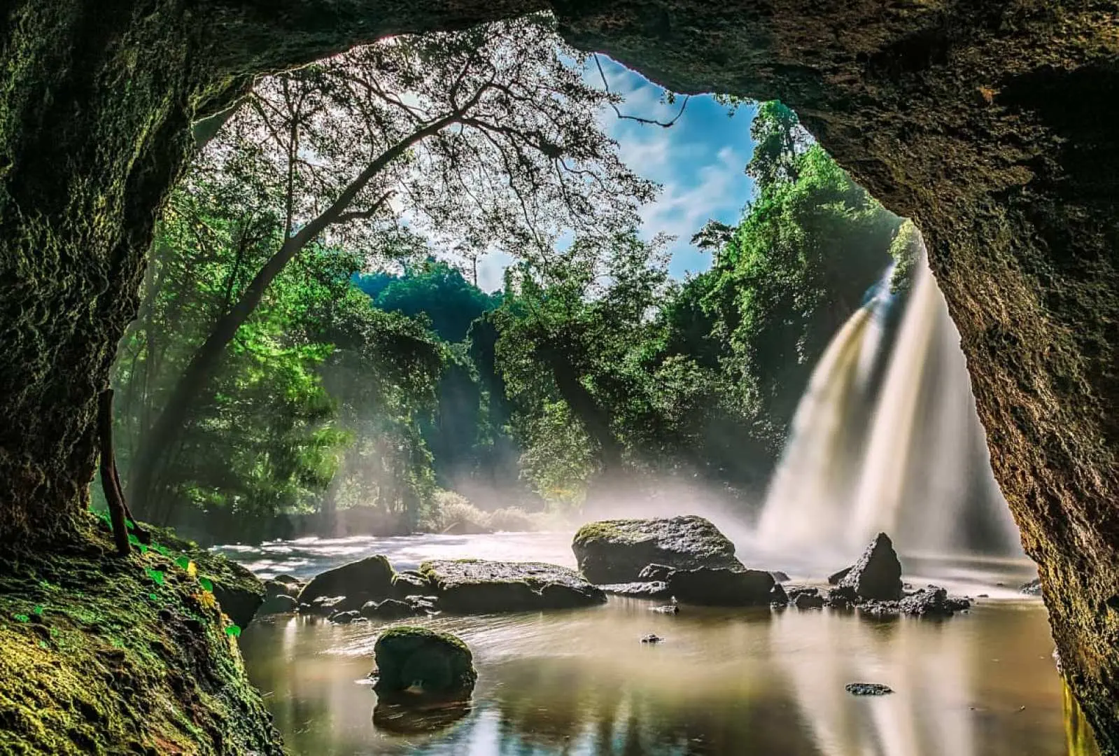 Nhìn ra từ hang động phủ đầy rêu phong trong Vườn quốc gia Khao Yai, thác nước hùng vĩ đổ xuống giữa rừng rậm tươi tốt, tạo nên cảnh quan thiên nhiên kỳ vĩ của Thái Lan.