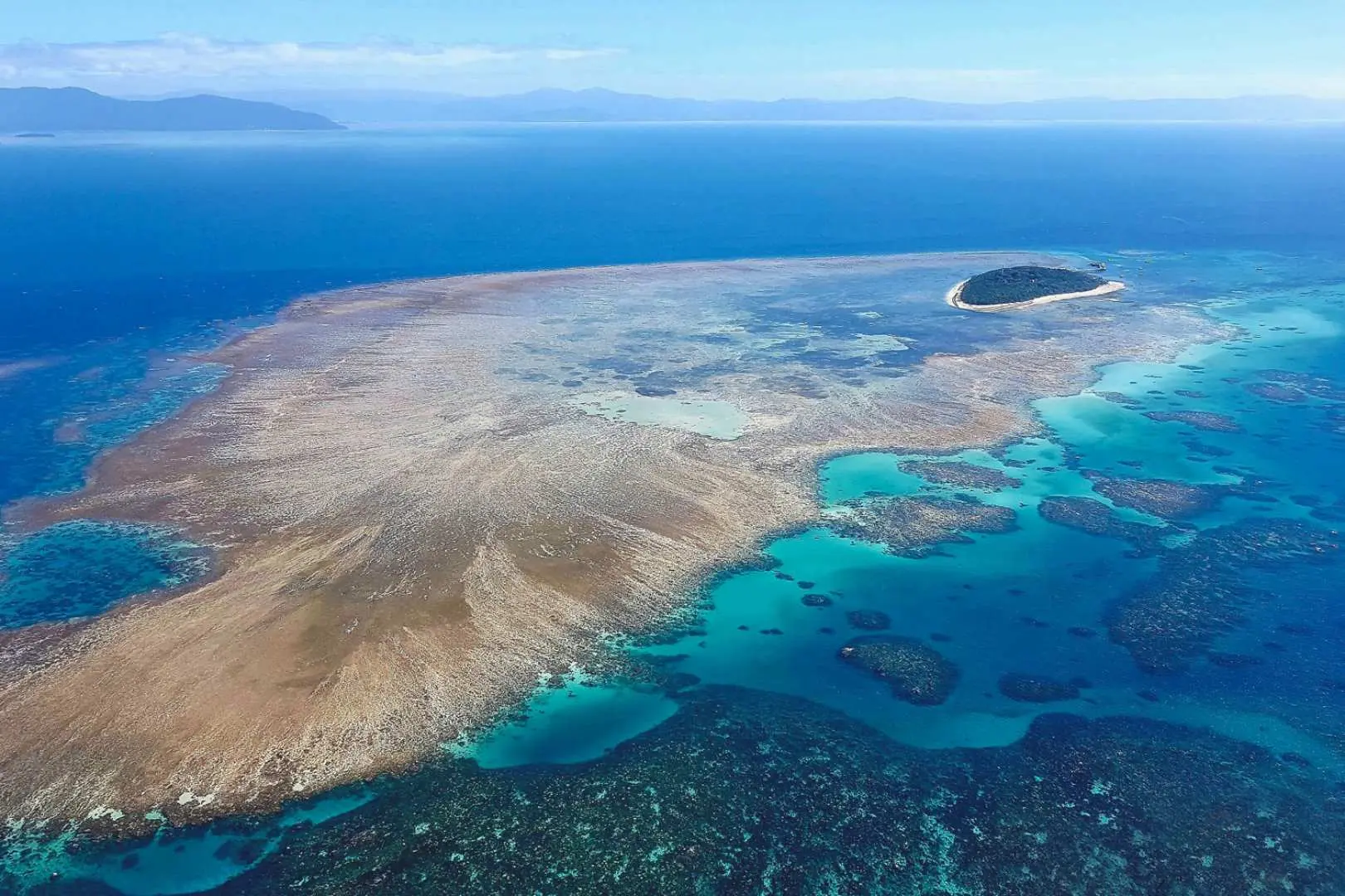 view of a large reef expanse with an island next to it