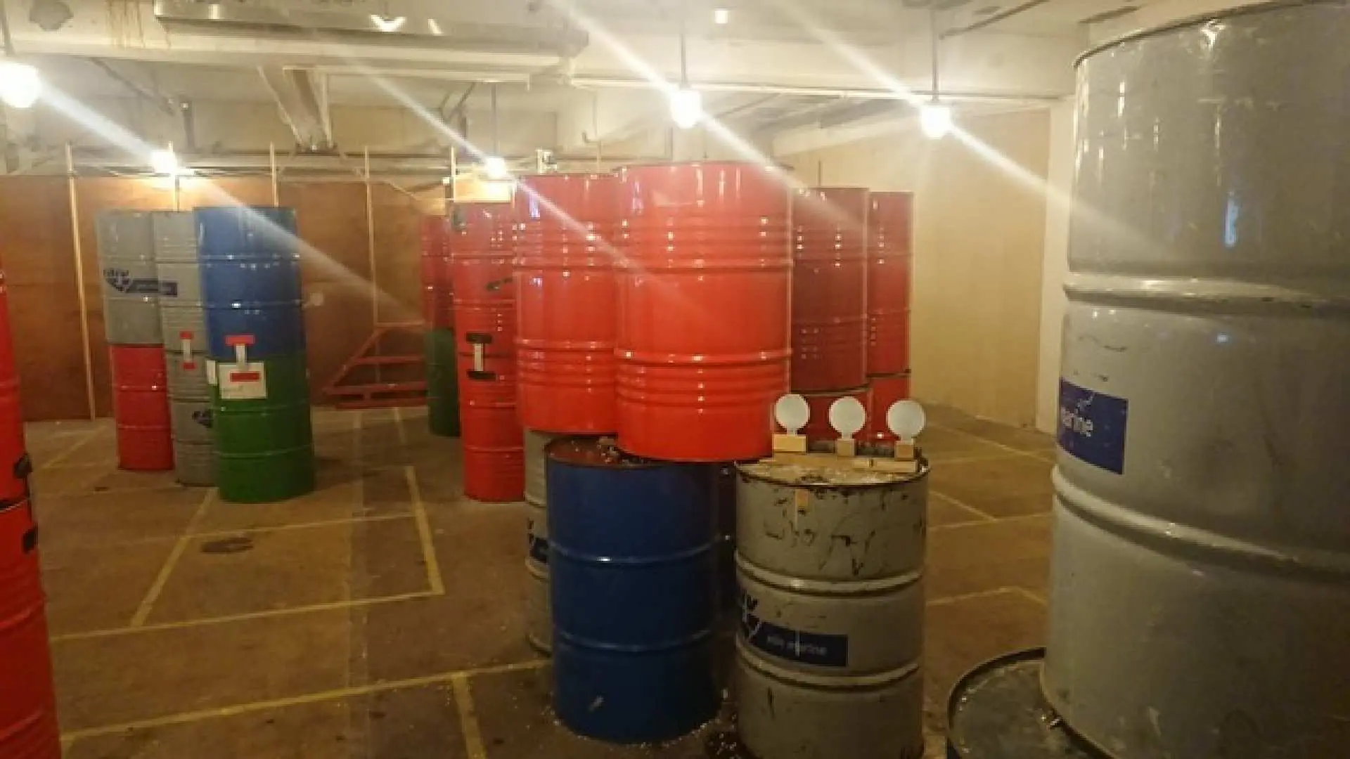 油塘室內CQB射擊場景，擺放著大量紅、藍、灰色油桶作為掩體，構成多變的戰術格局，適合啫喱彈槍或Nerf Gun Wargame對戰。
