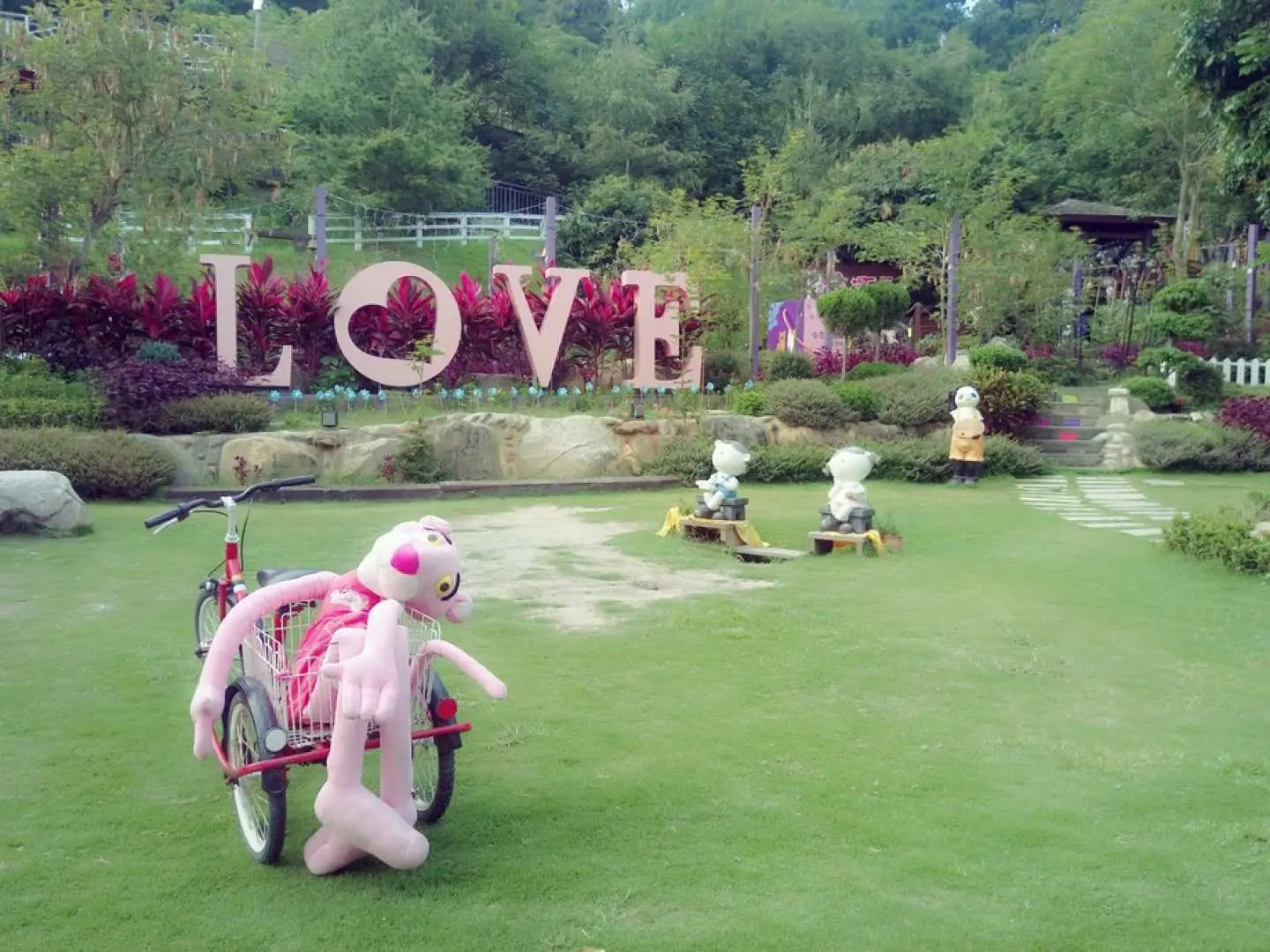 The giant 'LOVE' sign and a cute Pink Panther bicycle on the spacious lawn at Changhua Tonight Star Leisure Farm, making it a popular photo spot for couples.