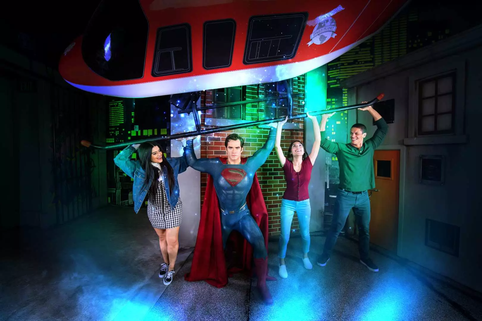 Visitors demonstrating superhuman strength by posing with Superman's wax figure to hold up a crashed helicopter prop at Madame Tussauds Orlando.