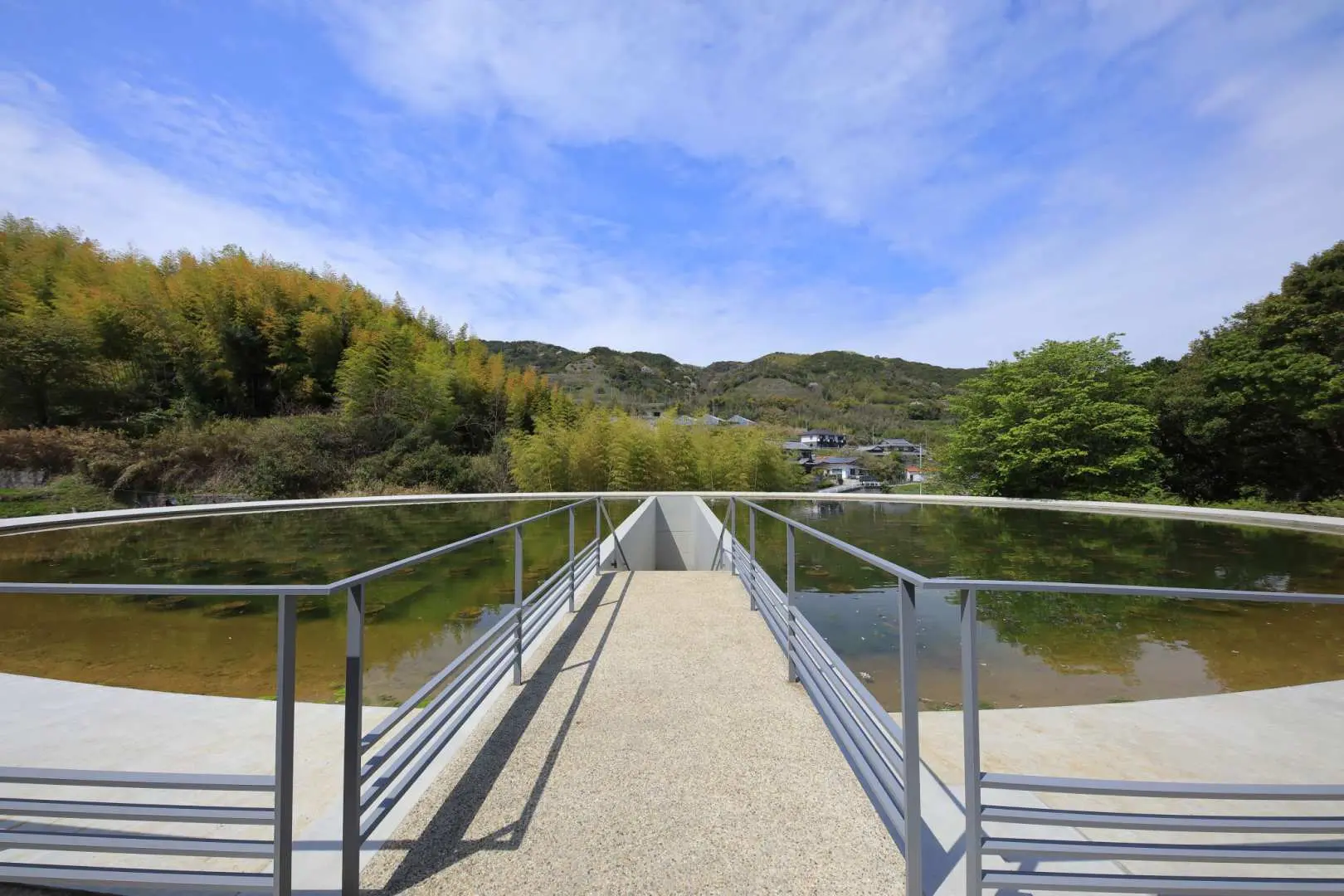 Honpuku-ji Water Temple by Tadao Ando, where visitors walk along a central path flanked by elliptical lotus ponds, showcasing minimalist architectural beauty integrated with nature.