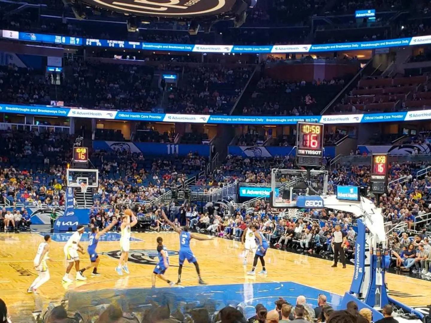 Close-up view of an Orlando Magic NBA game, capturing players in intense action on the court. The scoreboard displays live scores, offering fans an up-close experience of top-tier professional basketball.