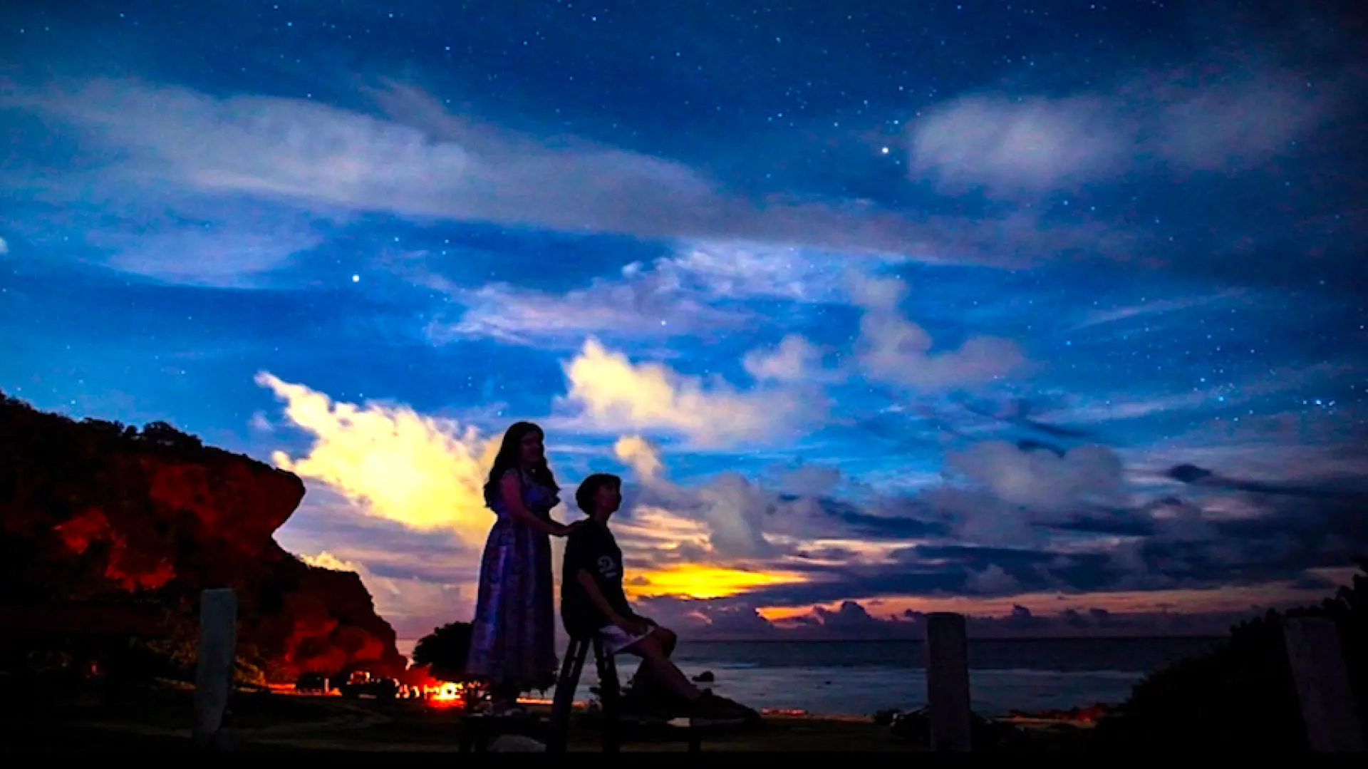 Cặp đôi tận hưởng tour ngắm sao lãng mạn ở Guam, với bầu trời chạng vạng đầy sao và mây trên biển.