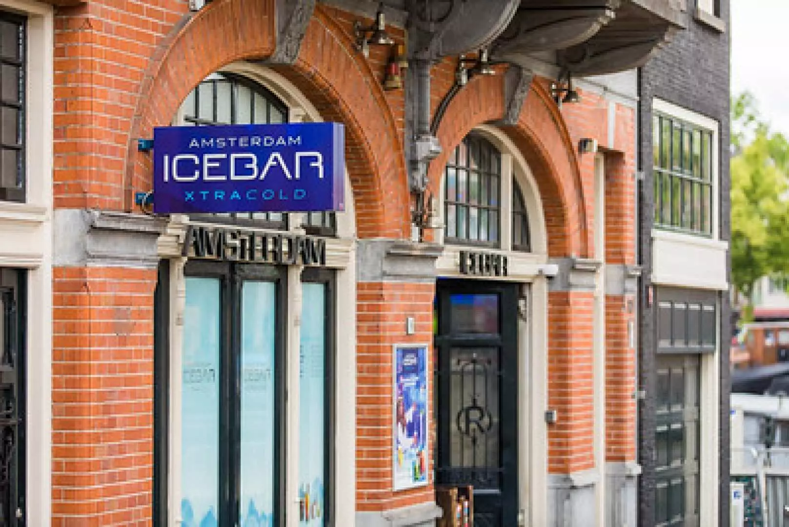 アムステルダムのアイスバーの外観。レンガ造りの建物にアーチ型の窓があり、上には「AMSTERDAM ICEBAR XTRA COLD」の青い看板が目を引く。