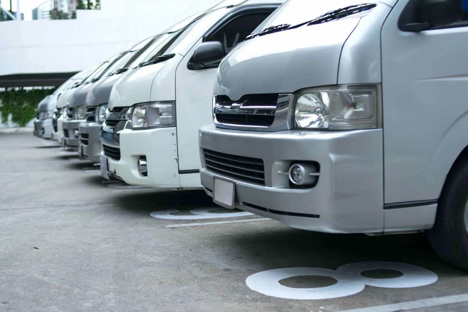 A fleet of comfortable white vans parked in Bali, ready to provide convenient and reliable transportation for tourists participating in this incredible day tour.