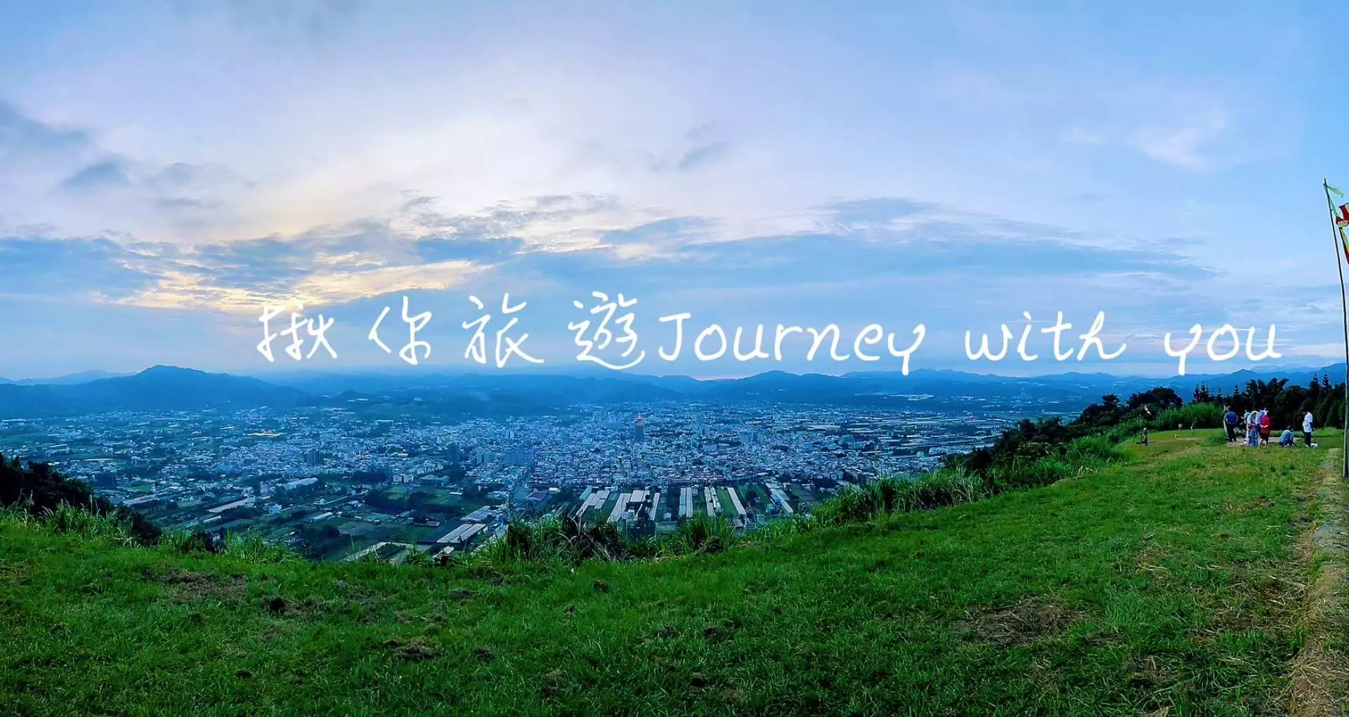 在虎啸山庄俯瞰南投市区夜幕降临前的广阔全景，夕阳余晖洒满远方山峦与城市灯火，感受迷人的日落风光。