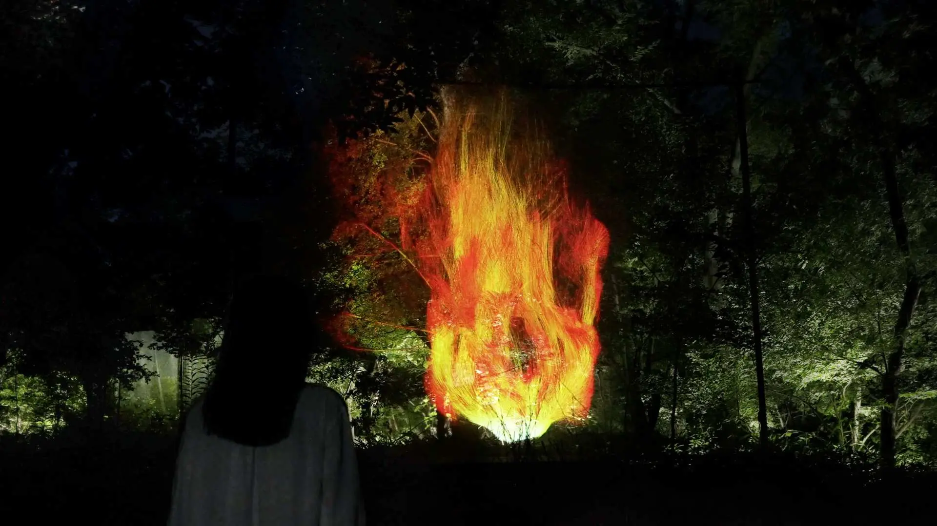 teamLab Botanical Garden Osaka showcases virtual digital flame art, radiating intense light in the dark forest, creating a visually stunning experience.