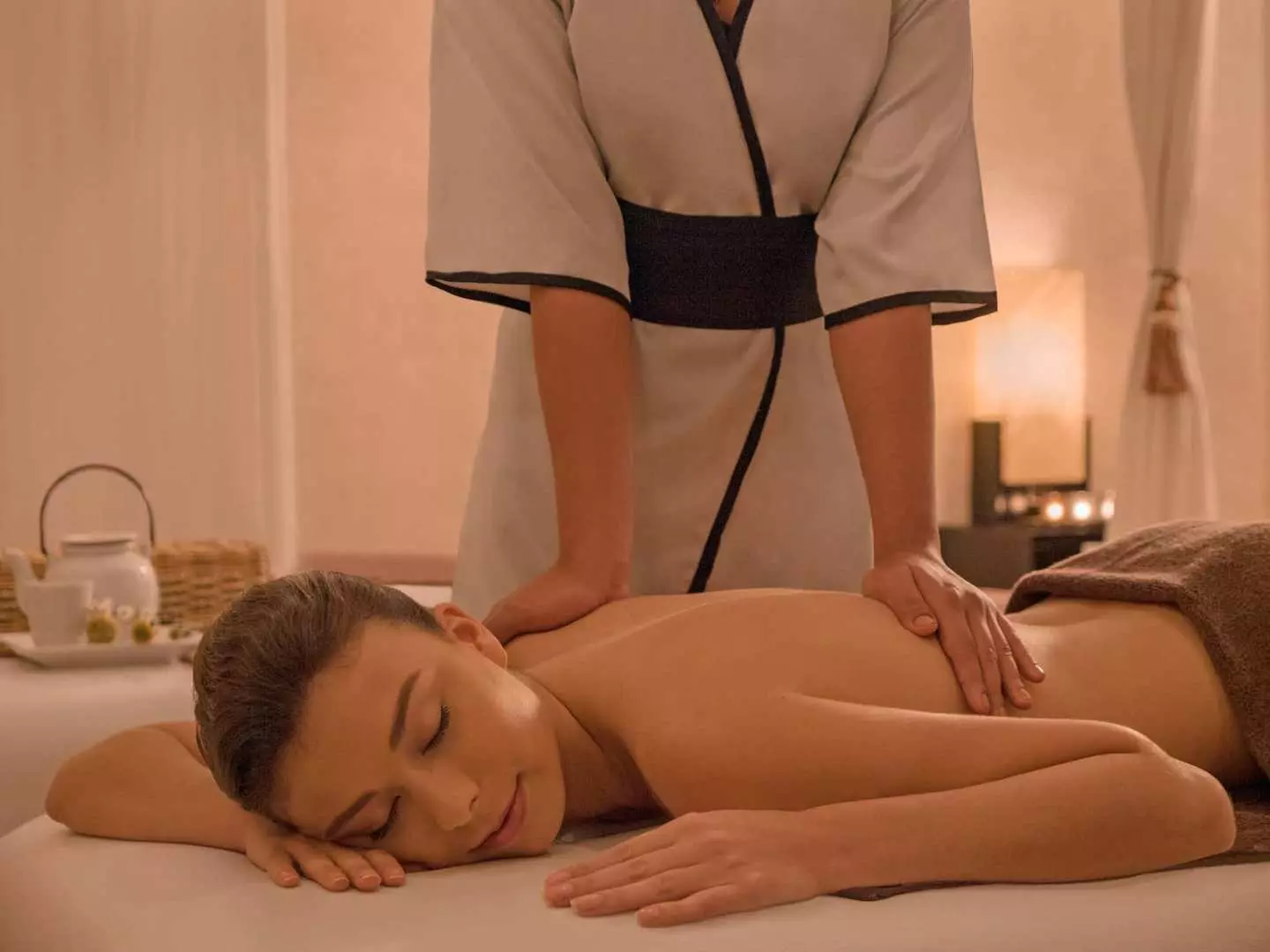A professional therapist skillfully performing a soothing traditional Filipino back massage on a client, emphasizing the relaxing experience at Surrender Day Spa.