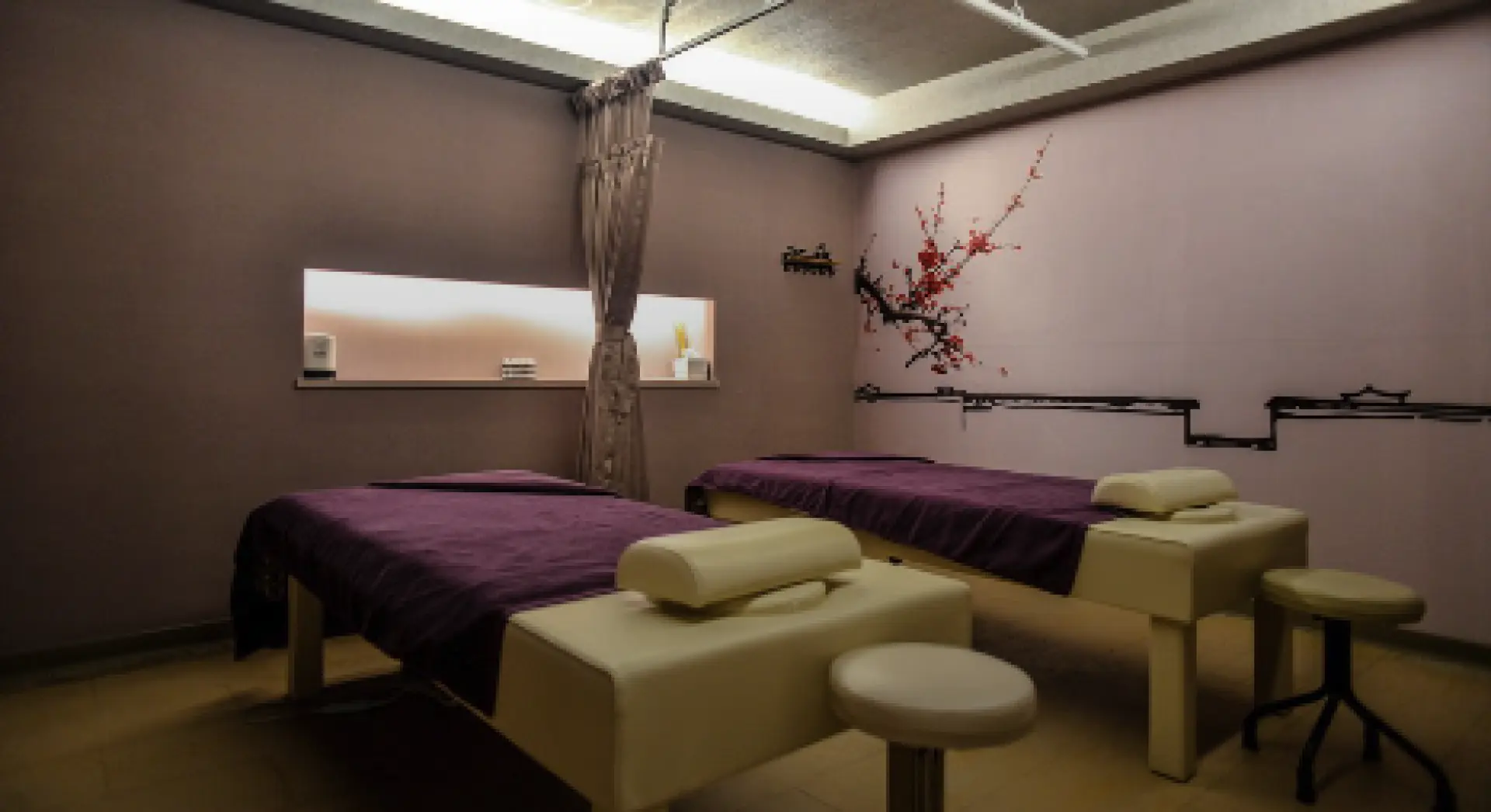 台北禾匯足體養生行館雅緻的雙人按摩包廂，提供全身經絡指壓服務，牆面裝飾著東方風格花鳥圖，營造寧靜舒適的體驗空間。
