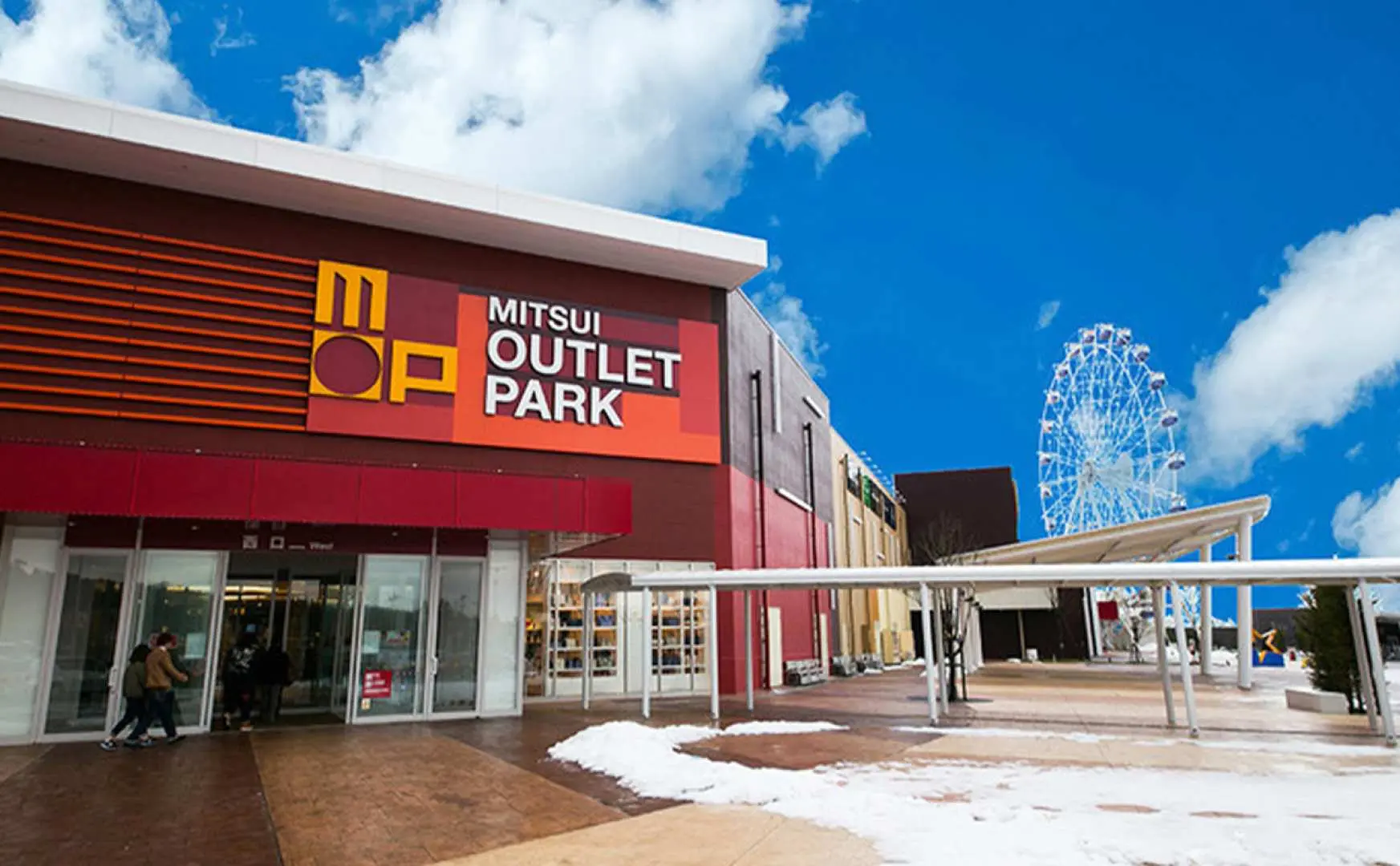 神戶三田MITSUI OUTLET PARK的主要入口，設計現代時尚，旁邊隱約可見摩天輪，為購物體驗增添樂趣。