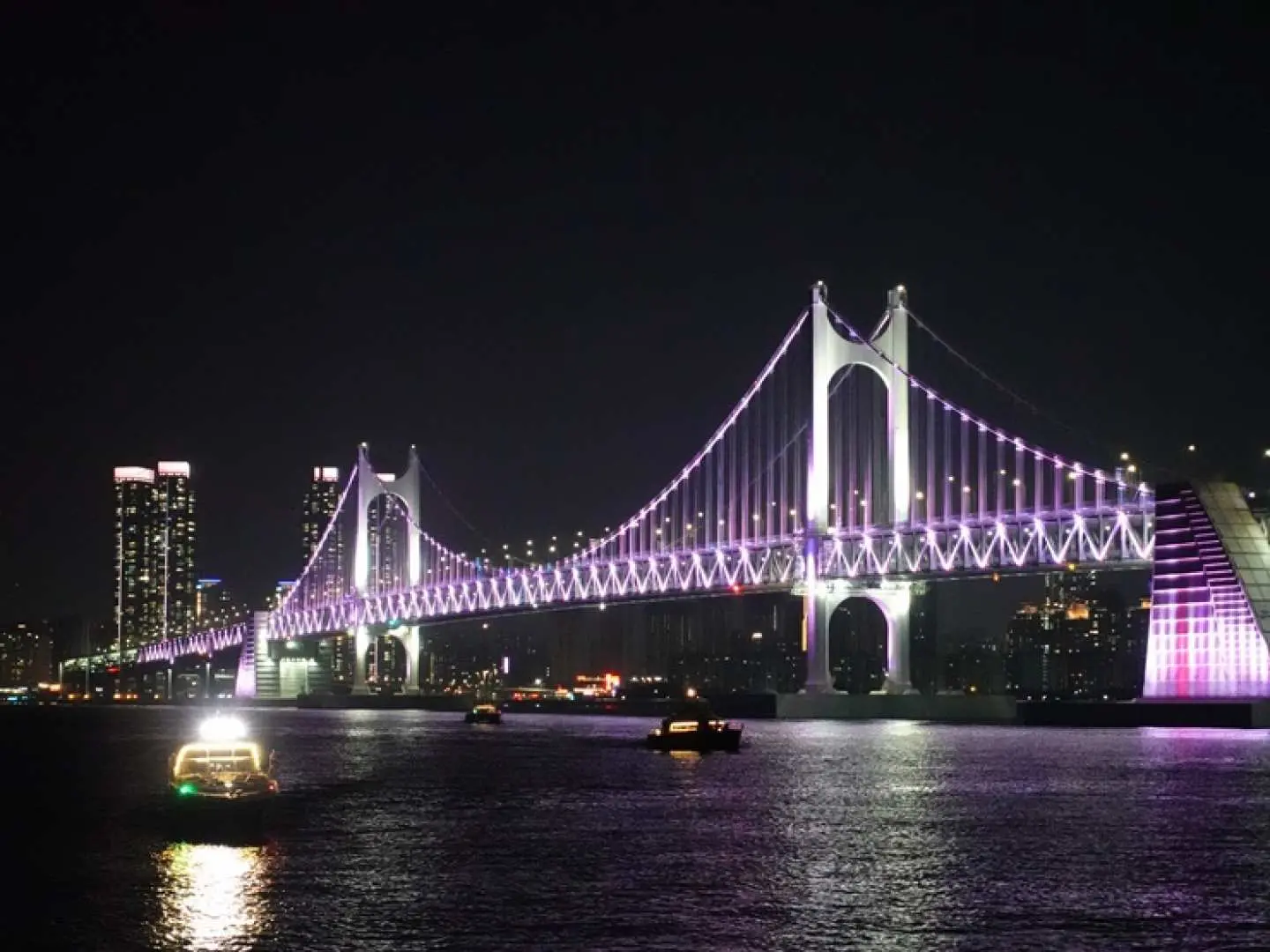 釜山廣安里夜景遊艇之旅，從海上遠眺壯麗的廣安大橋，燈光點綴下的橋身格外迷人。