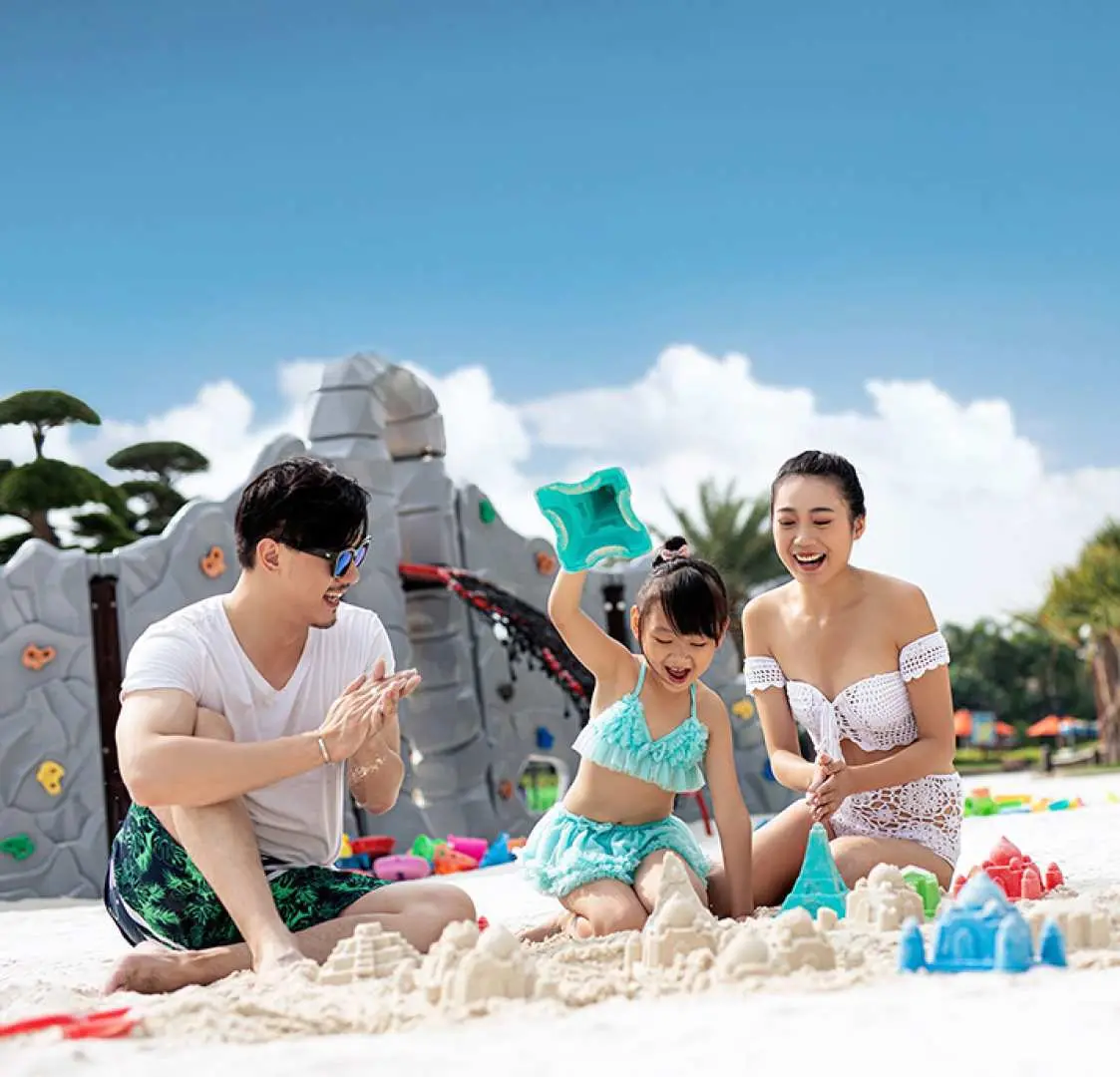 一家人在珠海長隆橫琴灣水世界的「海灘花園」玩樂，孩子們堆沙堡，父母陪伴，享受陽光下的家庭時光。