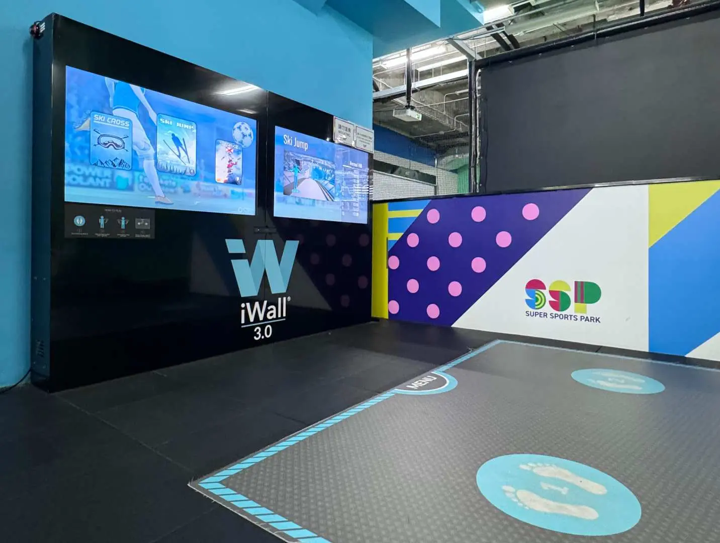 Super Sports Park奧海城iWall 3.0體感互動遊戲區，大螢幕展示多款遊戲，地下有腳步標示，準備迎接運動挑戰。