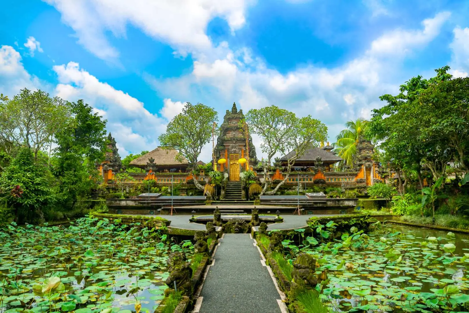 Beautiful water temple with intricate Balinese architecture surrounded by vibrant lotus ponds and lush greenery, a serene cultural landmark in Ubud.