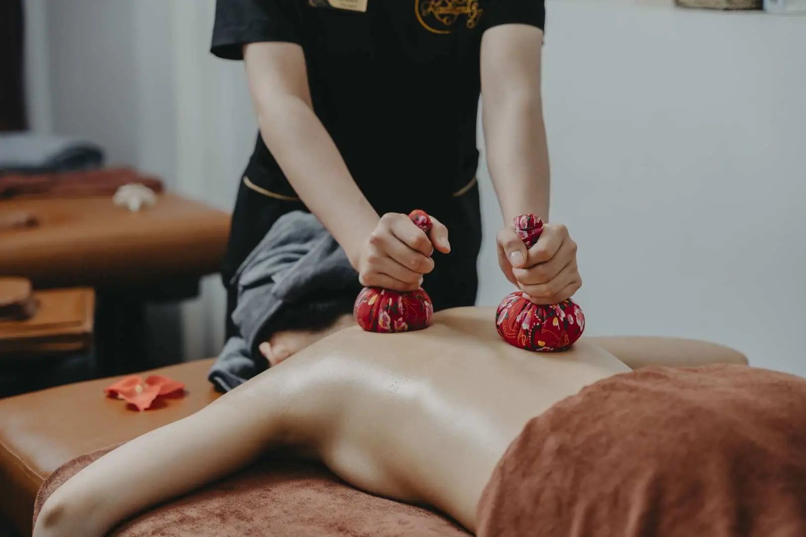 Kadupul Spa Hanoi: Therapist performs a deep back massage with herbal poultices to soothe muscles.
