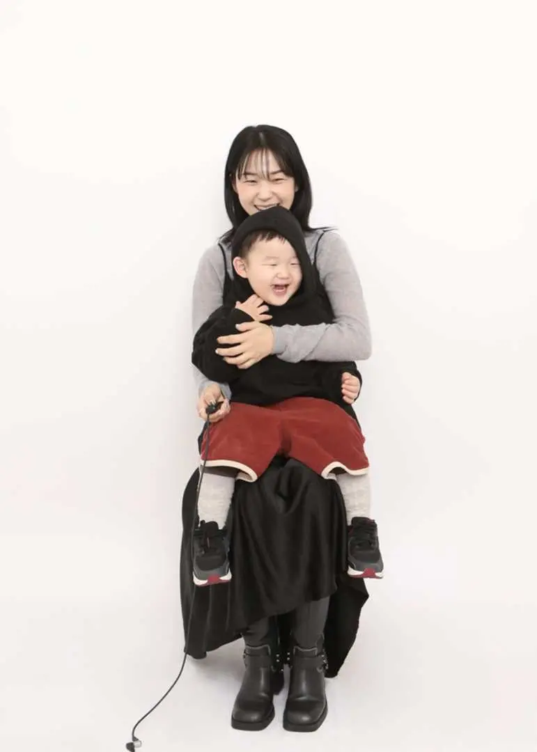 ภาพขาวดำอันอบอุ่นใจของแม่ที่โอบกอดลูกน้อยที่กำลังหัวเราะอย่างมีความสุขที่สตูดิโอถ่ายภาพตนเอง Odity Mode ในฮงแด โซล บันทึกความสัมพันธ์สไตล์เกาหลีที่เปี่ยมด้วยความรักของพวกเขา