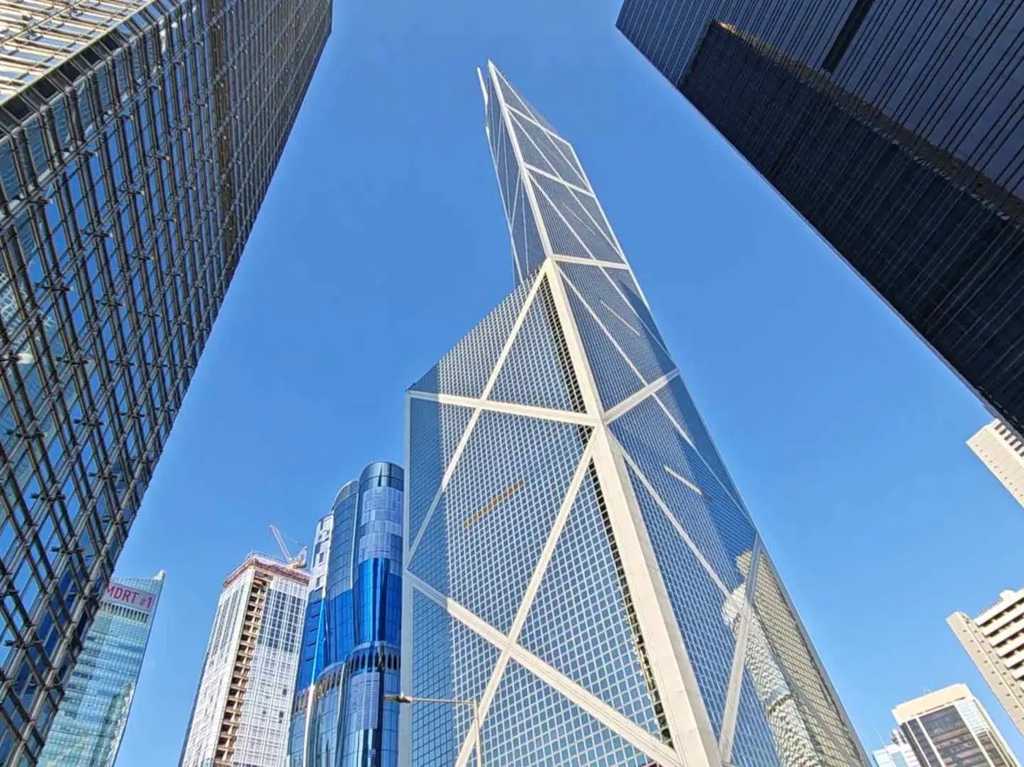 Striking upward view of iconic modern skyscrapers in Hong Kong's Central district, including the Bank of China Tower, showcasing the city's impressive architecture on the Hong Kong Island Tour.