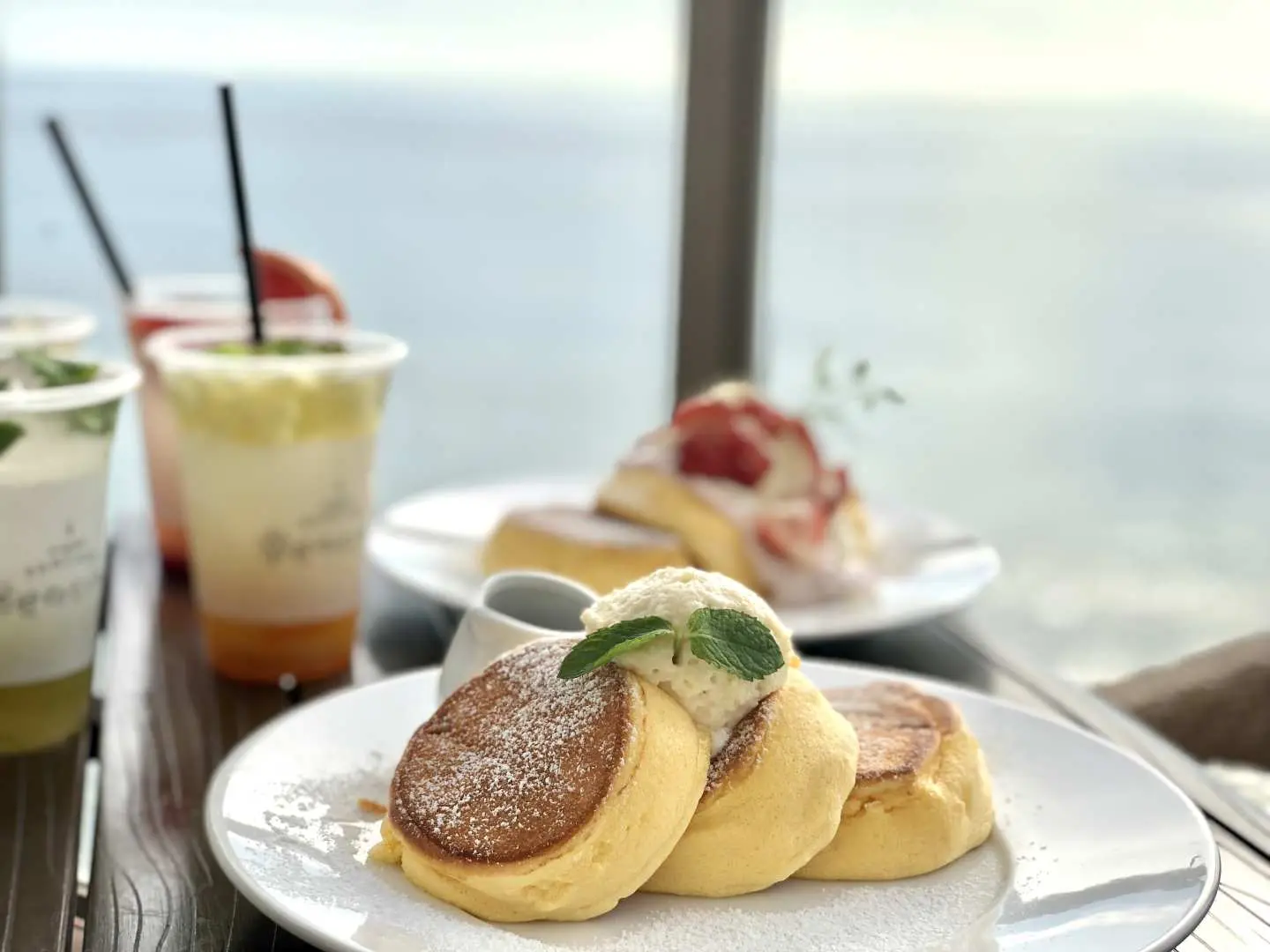 Món tráng miệng đặc trưng bánh kếp phồng với kem và đường bột từ Awajishima Terrace trên đảo Awaji, thưởng thức bên cửa sổ nhìn ra biển, một món ăn lãng mạn và hấp dẫn.