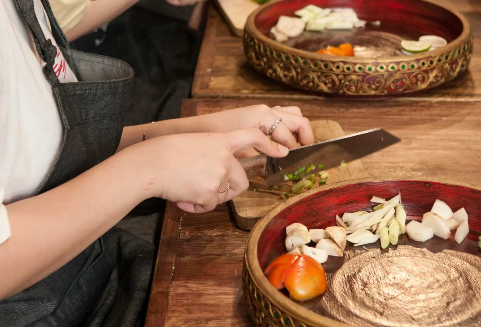 In the Sabieng Thai cooking class in Bangkok, students meticulously learn to chop fresh spices required for Thai cuisine, enhancing their culinary skills.