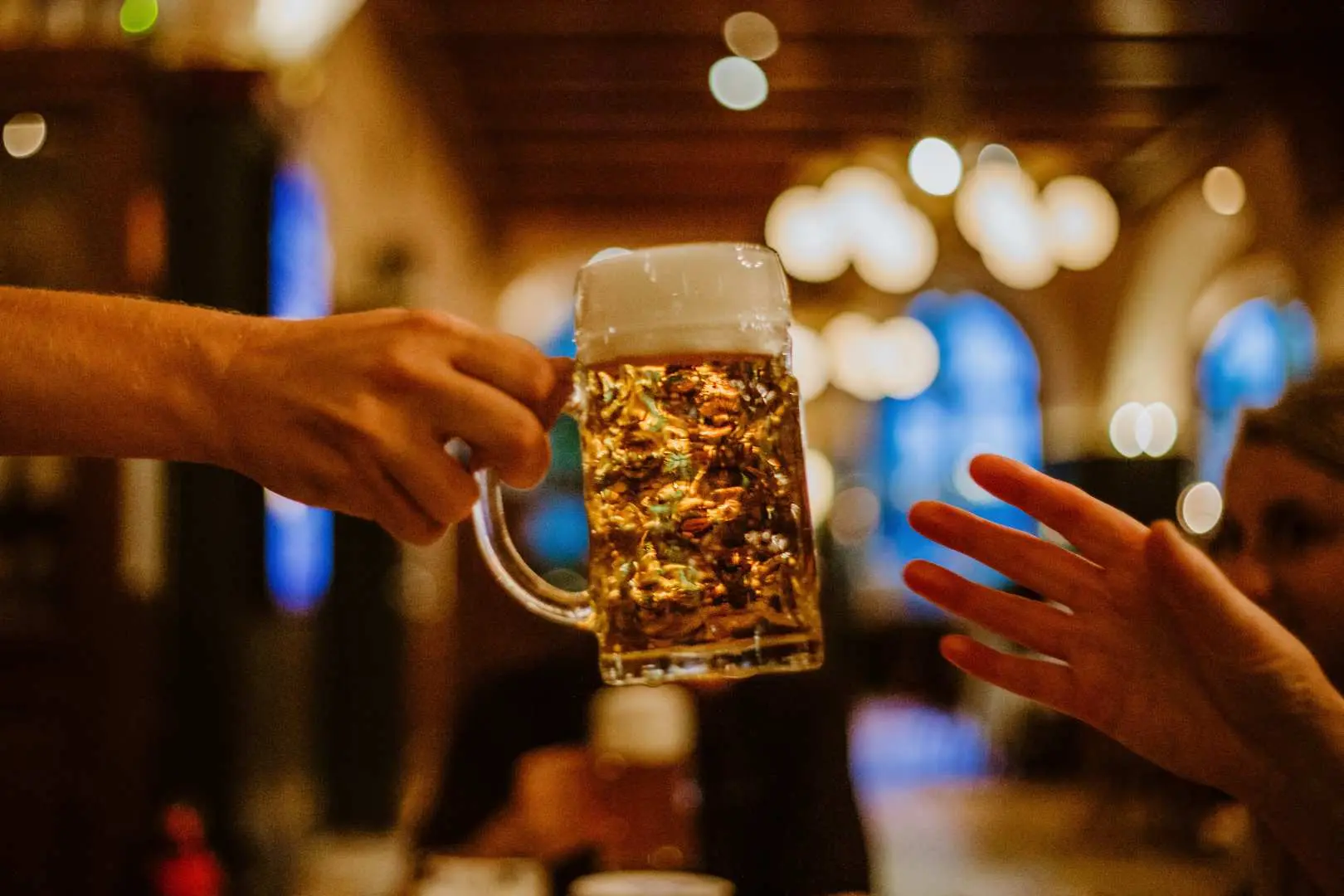 A lively toast with a traditional Bavarian beer in a bustling Munich pub, highlighting the authentic drink tasting experience during the Bavaria half-day tour.