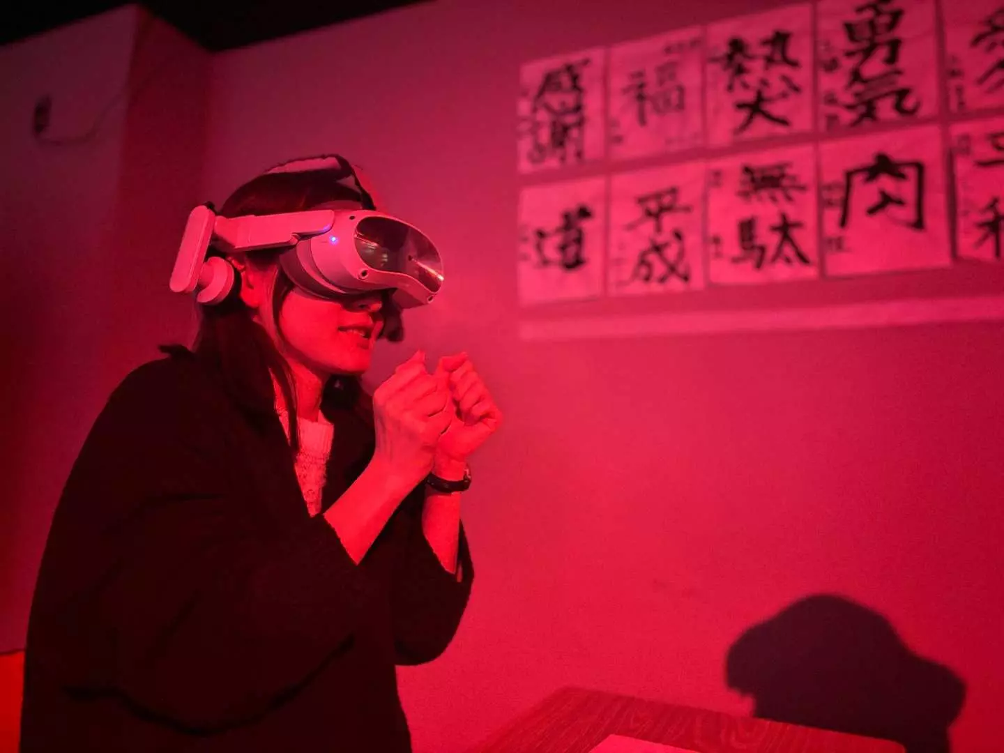 A visitor at RED° TOKYO TOWER wearing a VR headset, immersed in a virtual game within a red-lit Japanese-themed setting, experiencing next-generation entertainment that blends mind and technology, feeling Tokyo's futuristic vibe.