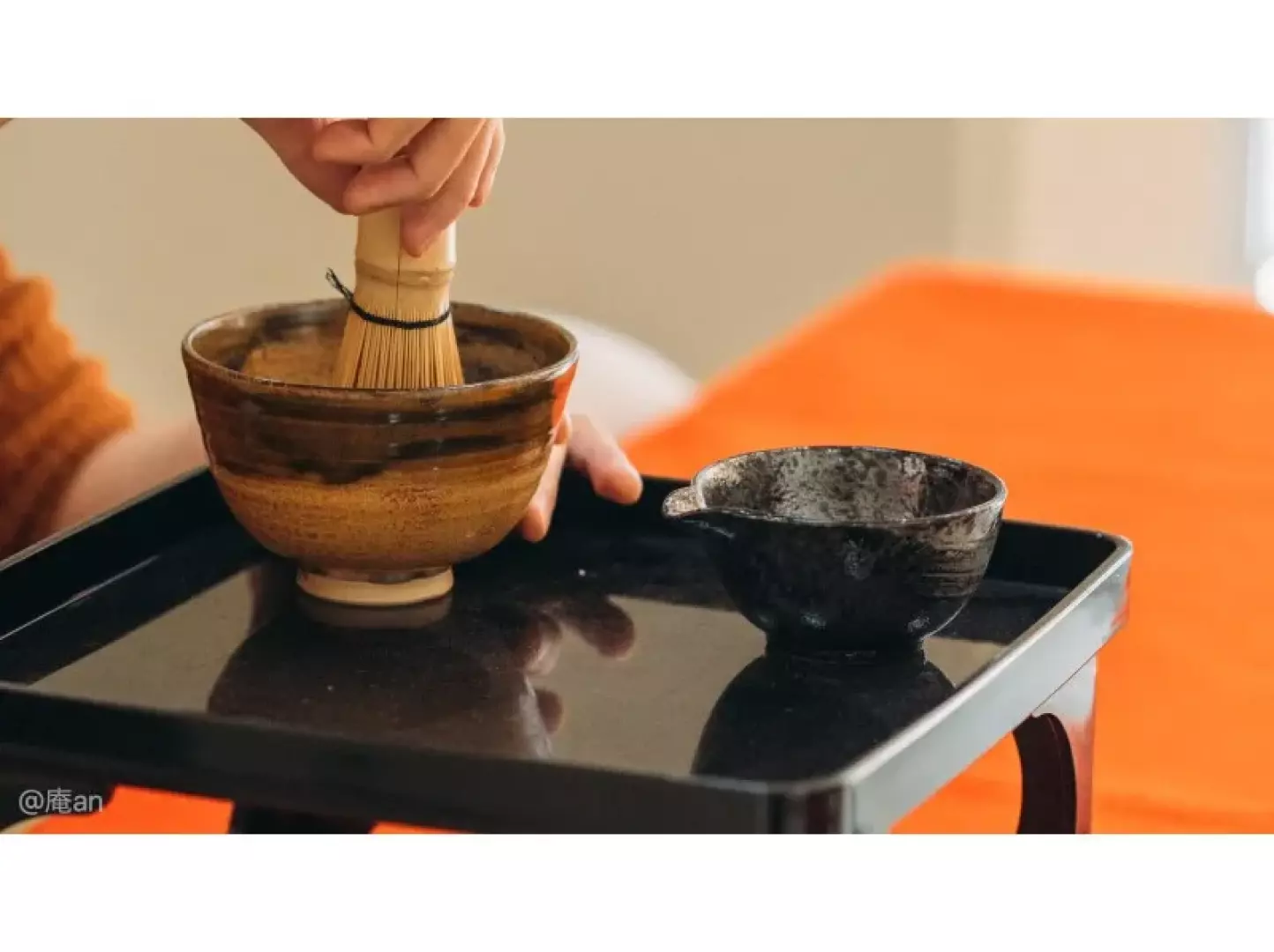 京都の茶道体験で、参加者が茶筅を使って特製抹茶を点て、濃厚な茶を準備し、日本の伝統文化を体験する様子です。