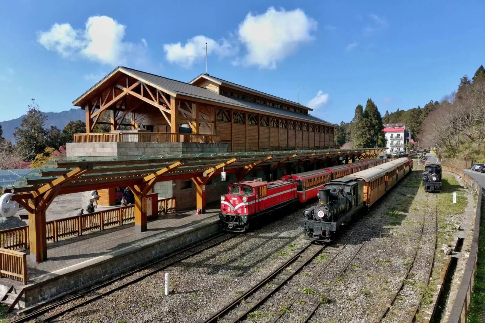 Alishan Zhushan or Zhaoping Station, featuring red and black forest railway trains parked on the tracks, embodying the historic charm of Alishan's railway.