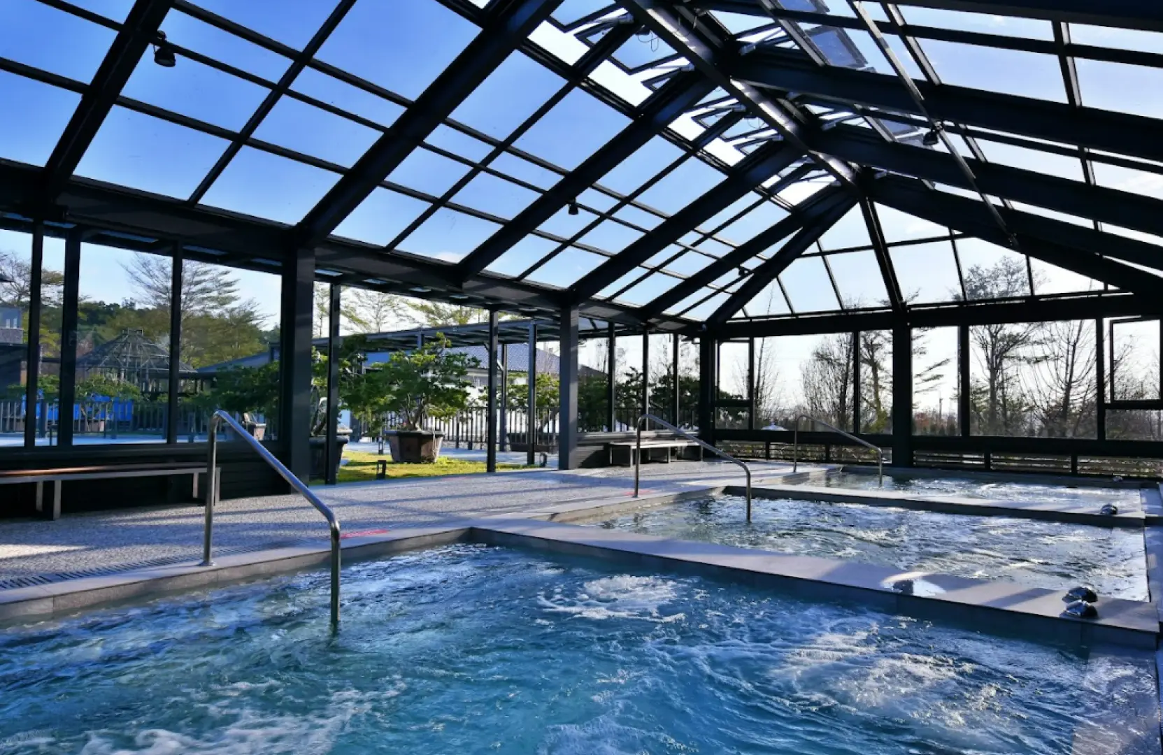 享沐時光莊園渡假酒店採光極佳的室內溫泉池，玻璃屋頂與大面窗戶設計，讓泡湯者在綠意環繞中享受溫暖水流與自然光。