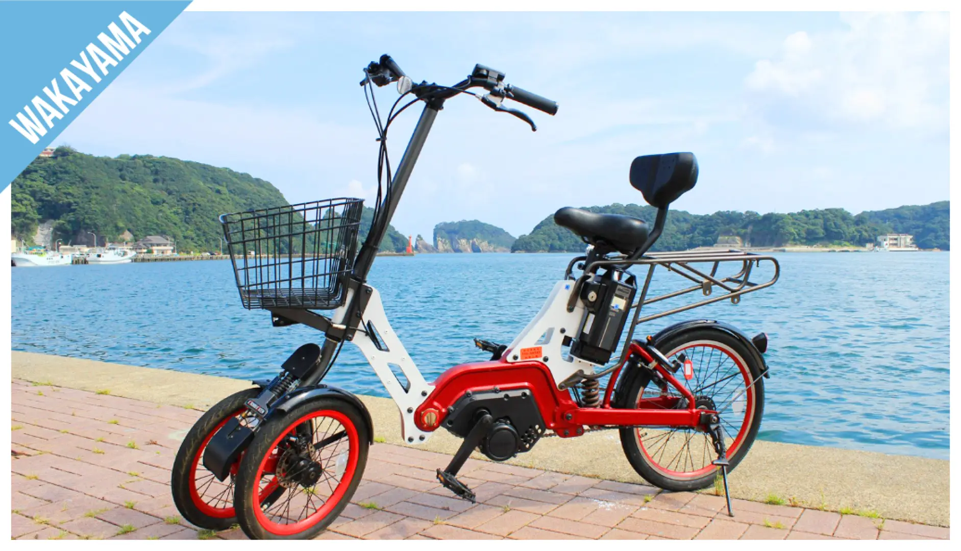 Wakayama electric bike parked along the coastline, with a backdrop of the blue sea and green hills, ideal for coastal exploration and outdoor activities.