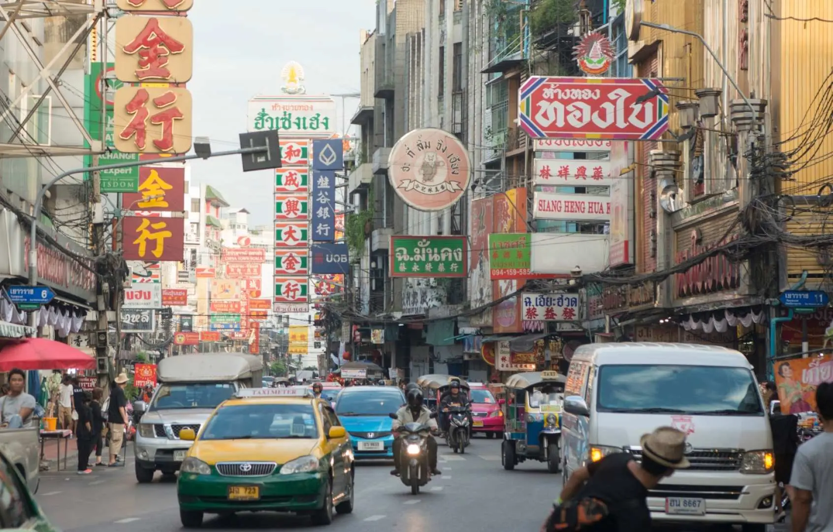 曼谷唐人街充滿活力的街景，密集的中文招牌、車輛和行人交織，呈現歷史街區的獨特魅力。