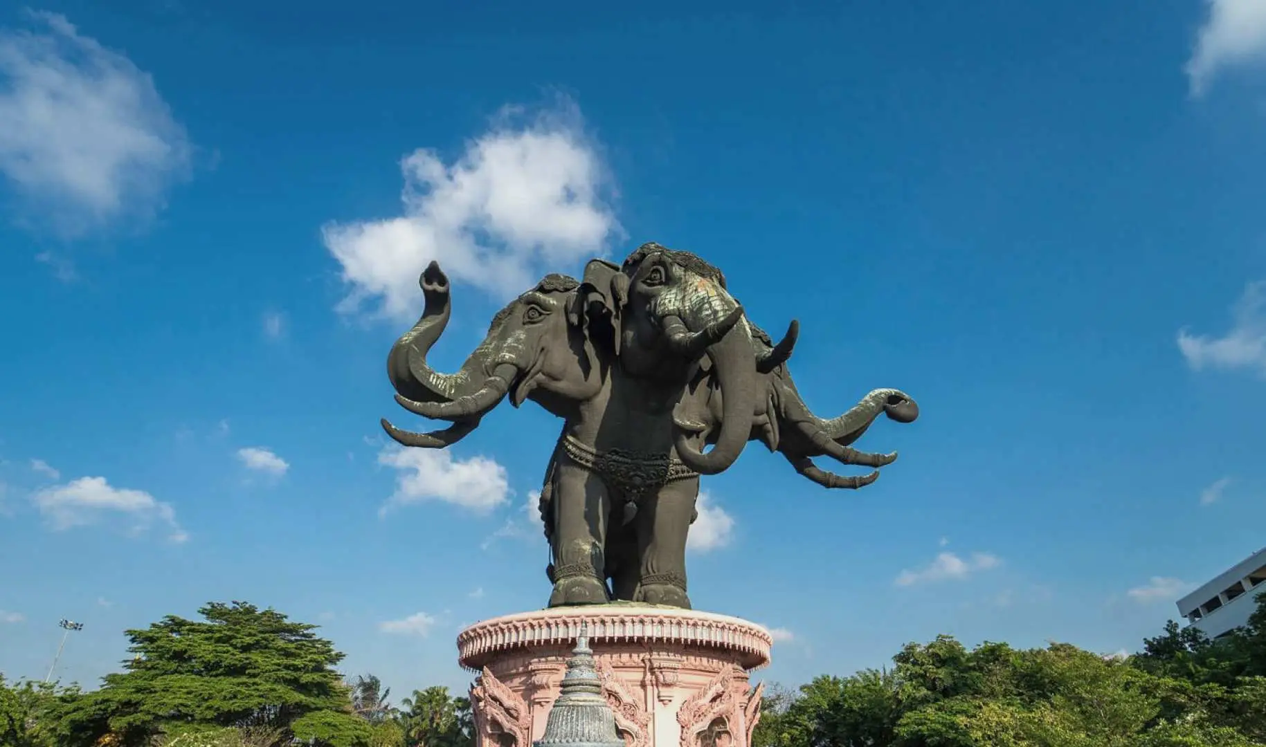 The colossal three-headed elephant statue outside Bangkok's Erawan Museum, majestically standing against a clear blue sky, a powerful symbol of Thai culture and art.