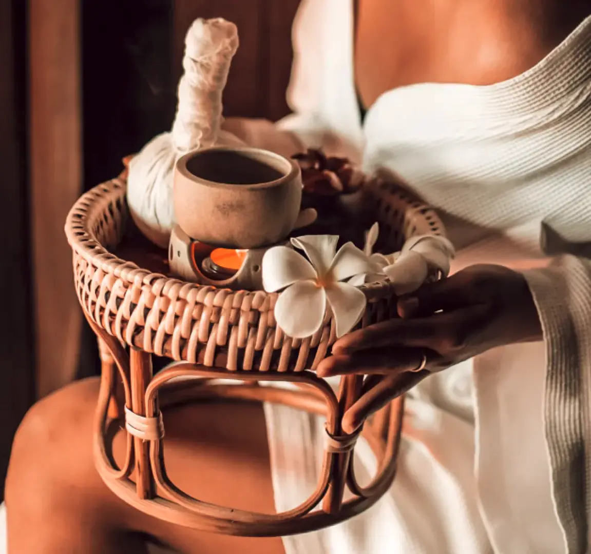 Spa essentials at a Kuala Lumpur wellness center in Malaysia, showcasing Balinese aromatic oils, herbal compresses, and frangipani flowers, enhancing a luxurious and relaxing massage experience.