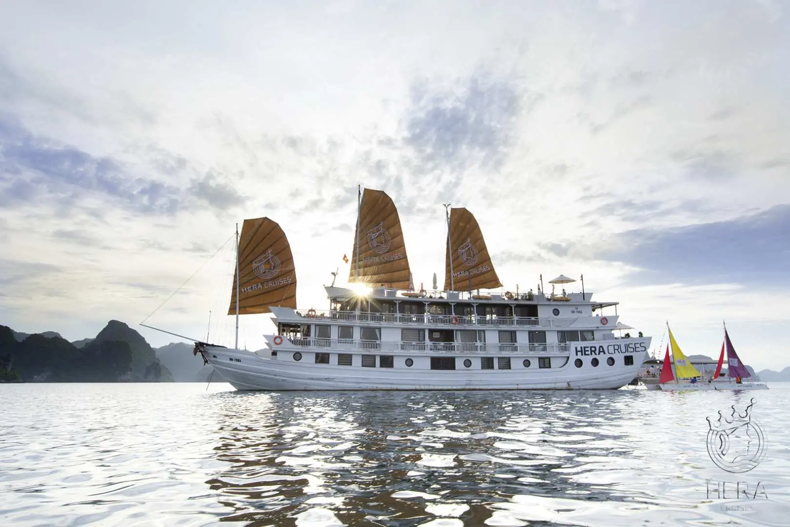 越南下龙湾Hera Grand豪华游轮，在碧绿海水中航行，其传统帆船造型与周围景致完美融合，气势磅礴。
