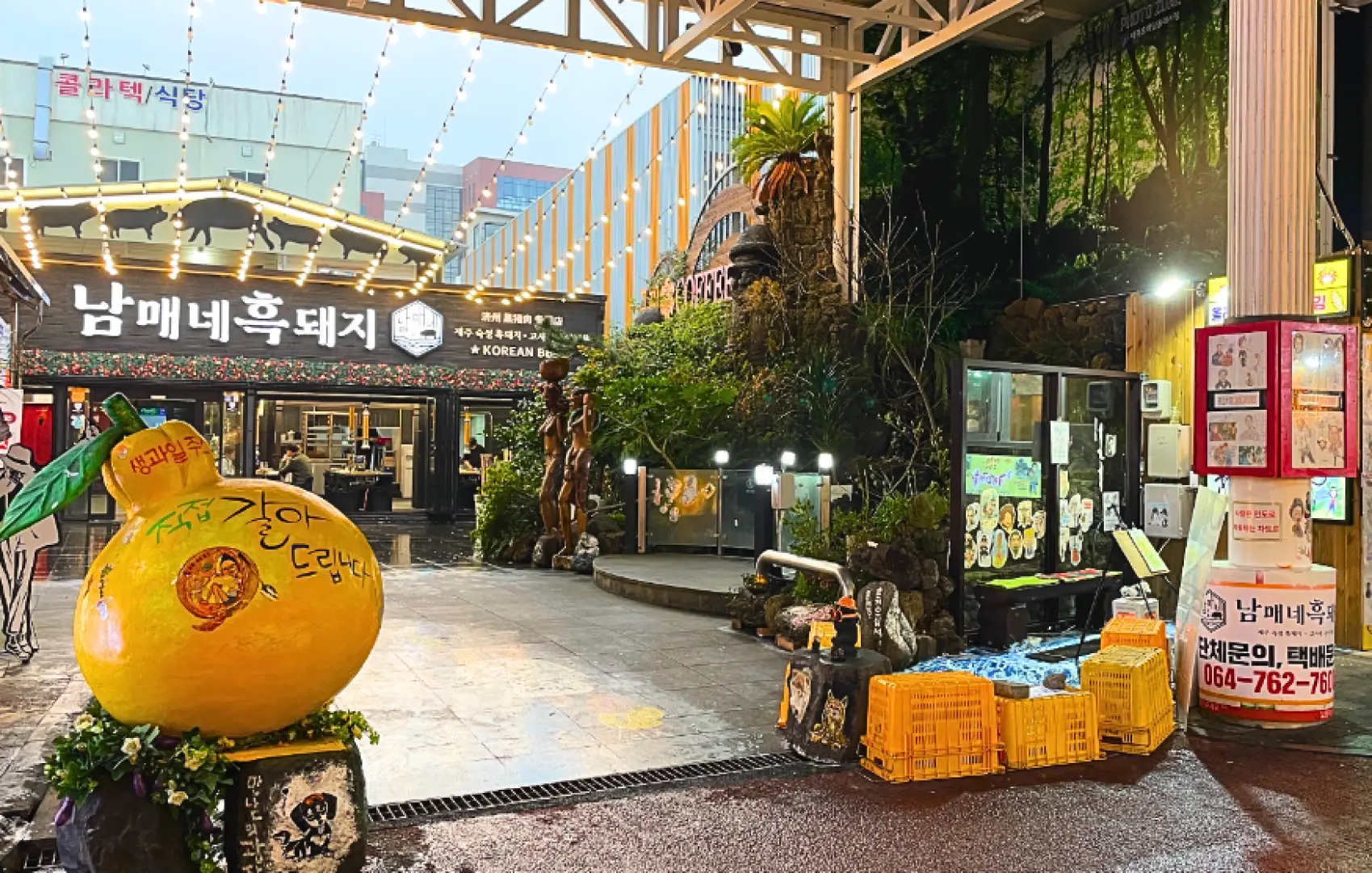 【在南國的暖陽下，找尋生活的原味：西歸浦每日偶來市場】 如果說東門市場是熱鬧的深夜嘉年華，那麼「西歸浦每日偶來市場」，就是一段與濟州在地日常最溫柔的邂逅。  踏入這座充滿活力的市場，你會驚訝於它的整潔與從容。陽光透過挑高的拱頂灑在乾淨的街道上，兩旁是整齊劃一的攤位，這裡沒有過度的叫賣，只有攤主們親切的笑容。市場中心設計了長長的流流水景與休息長椅，你可以隨性地坐下來，一邊看著當地人挑選最新鮮的漁獲，一邊品嚐手中剛出爐的美味，這種與當地生活「同步」的頻率，正是西歸浦最迷人的地方。