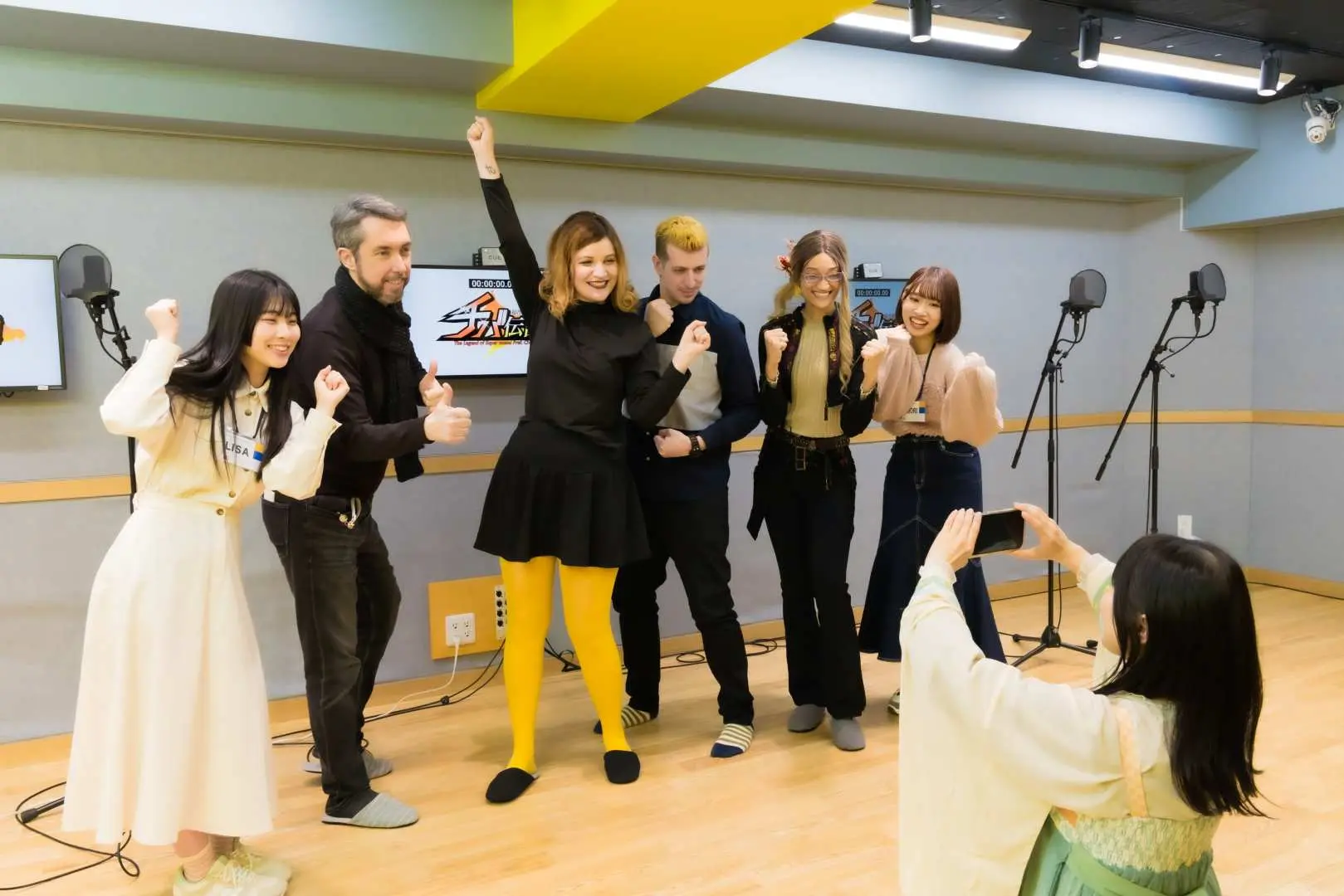 Participants joyfully pose for a memorable group photo inside the professional voice acting studio in Tokyo Ikebukuro, celebrating their unique experience.