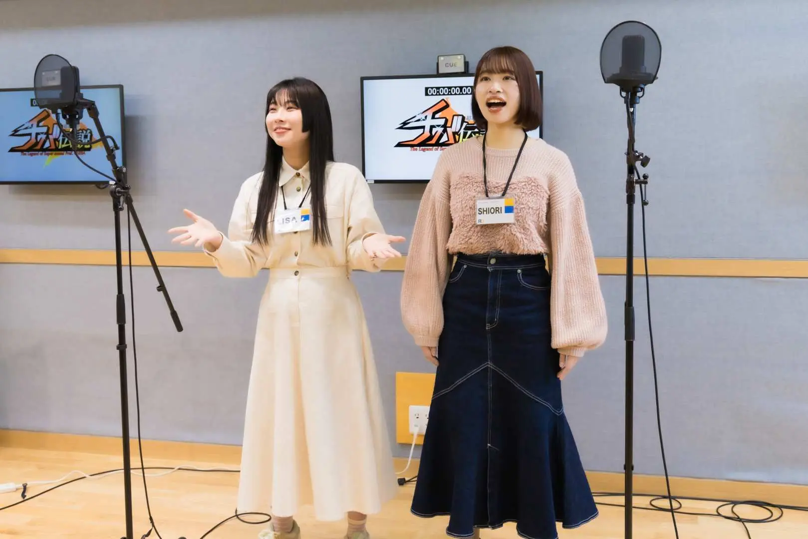 Two friendly Chinese-speaking guides or assistants in the Tokyo Ikebukuro voice acting studio are ready to assist participants, ensuring a smooth experience.