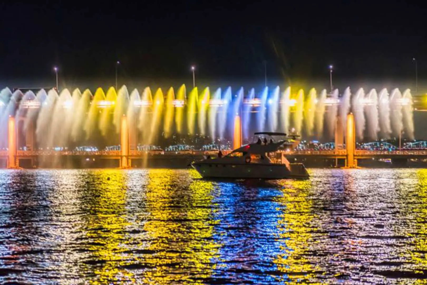 A luxury private yacht on the Han River watching the Banpo Bridge Moonlight Rainbow Fountain, with the brilliant light of the fountain reflecting on the water, offering an excellent viewing spot.