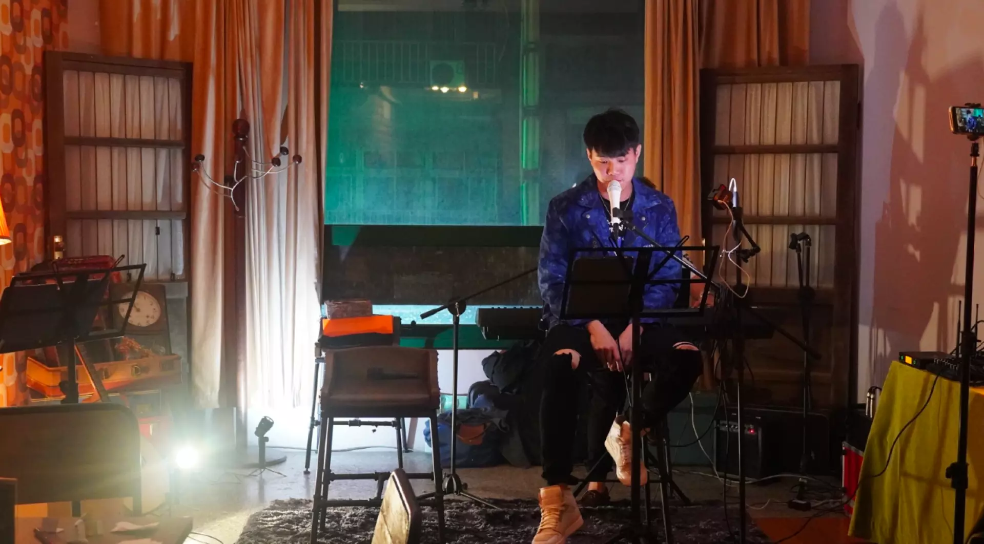 A musician expertly plays a keyboard on stage at the Taipei Dadaocheng Open Mic, providing live accompaniment for singers and jamming sessions in a warm setting.
