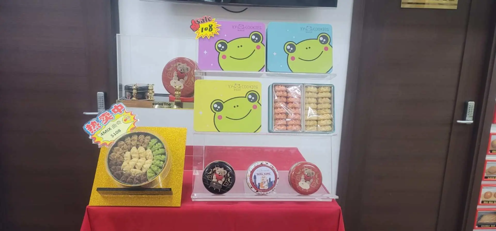 香港多多美麵包廠的專屬伴手禮展示，架上陳列著精美包裝的知名餅乾禮盒，包括青蛙吉祥物設計，是活動後的獨家贈品。