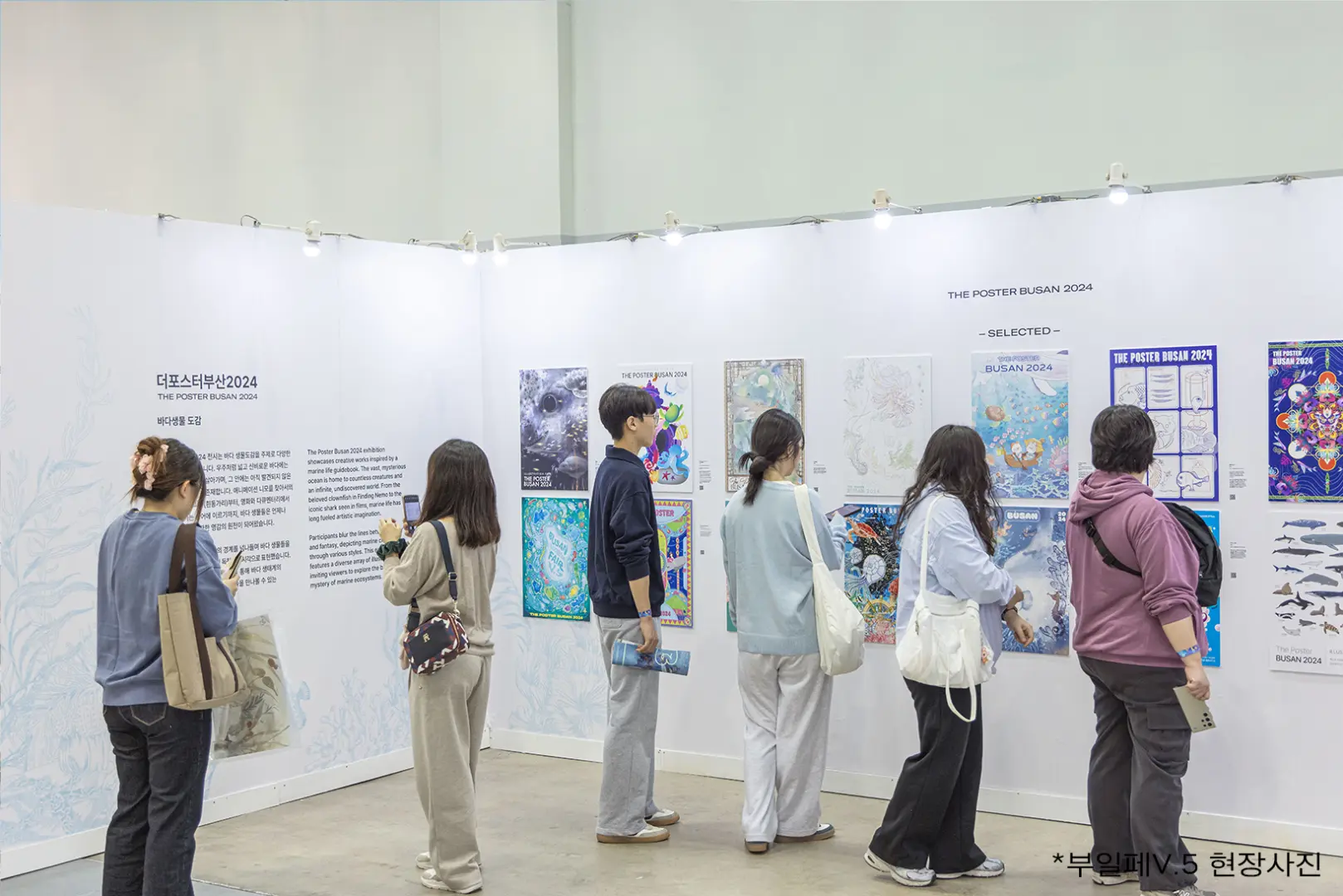 Visitors immersed in a gallery of exquisite ocean-themed illustrations at Busan Illustration Fair V.6, featuring diverse marine life and underwater landscapes.