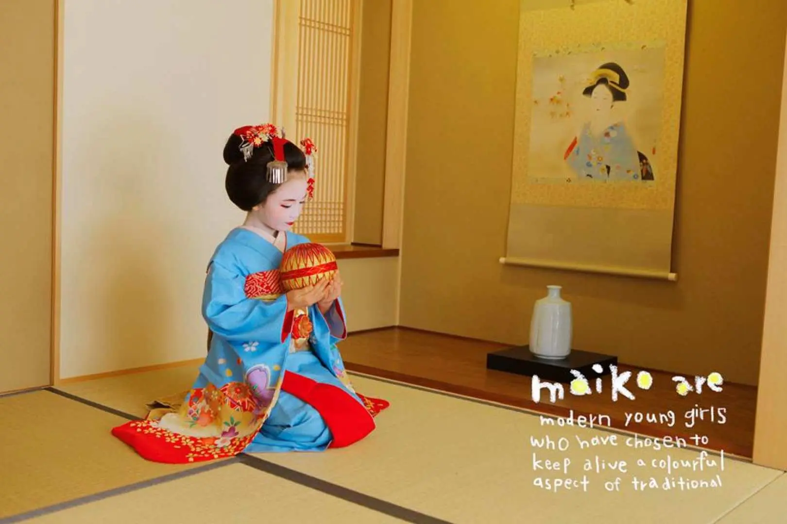 Kyoto child maiko in elegant blue kimono, kneeling gracefully with a temari ball, photographed in a traditional Japanese room.