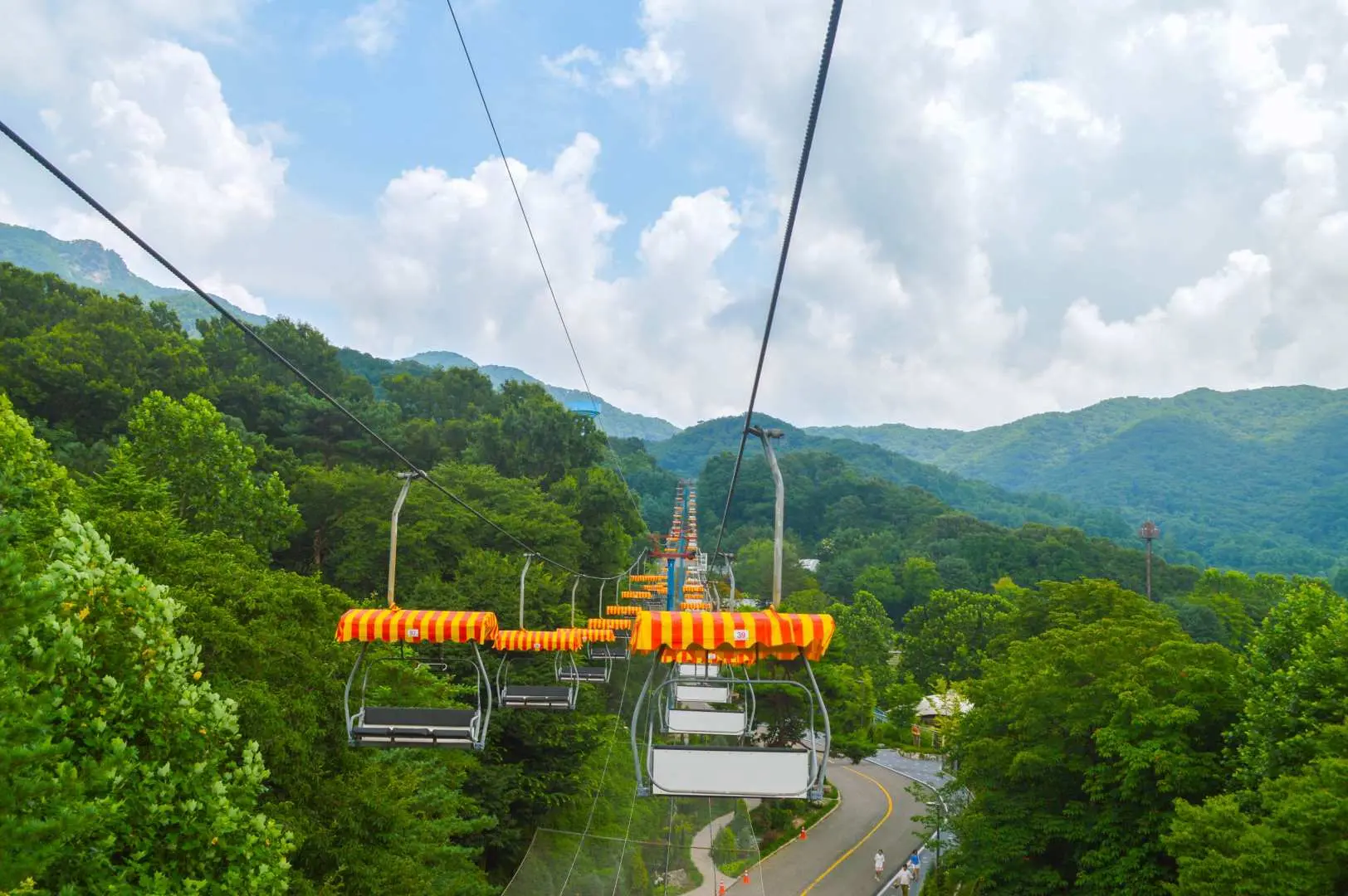 首爾大公園天空纜車延伸至遠方山林，俯瞰廣闊綠意與連綿山丘，享受開闊視野。