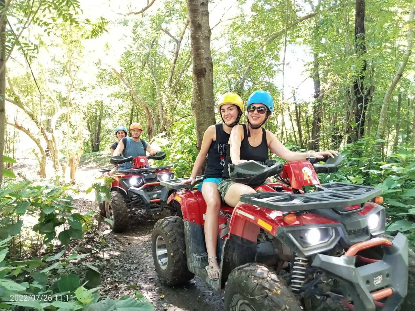 Two tourists riding ATVs on a dusty forest trail in Chiang Mai, enjoying a thrilling jungle adventure during their ATV off-road half-day tour.