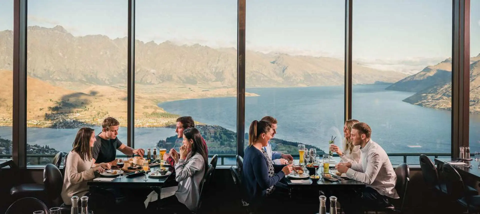 Diners savor a delicious buffet with unparalleled floor-to-ceiling views of Queenstown and Lake Wakatipu from the Skyline Gondola restaurant.