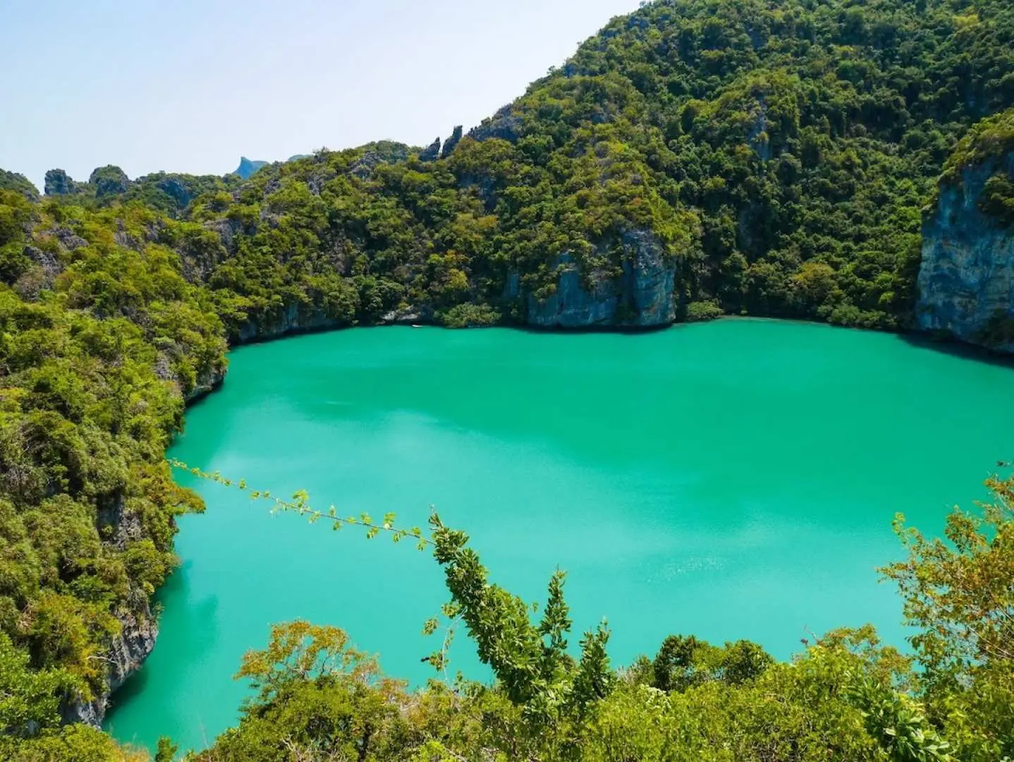 The iconic Emerald Lake (Talay Nai) within Angthong National Marine Park in Koh Samui, a stunning emerald green lagoon encircled by verdant limestone cliffs, offering a picturesque view.