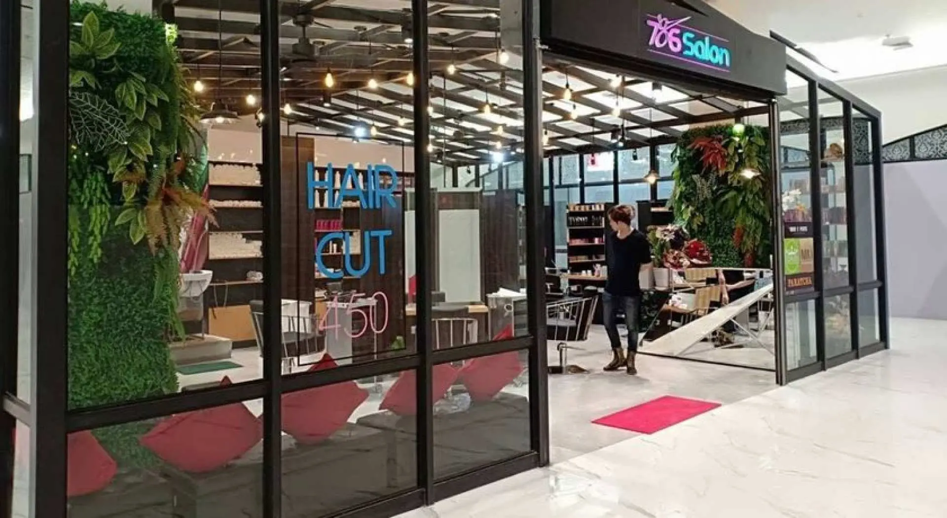 曼谷The Market商場內786 Salon的現代化外觀，玻璃門面映射出室內溫馨燈光，「HAIR CUT」霓虹字樣強調其專業剪髮服務。