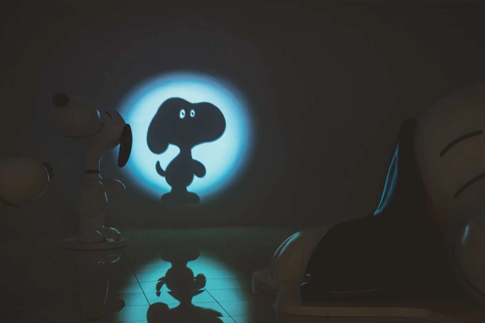 Buổi trình chiếu ánh sáng ban đêm tại Bảo tàng Snoopy Tokyo, nơi các chùm sáng xanh chiếu hình bóng Snoopy đáng yêu trong bóng tối, toát lên vẻ quyến rũ độc đáo.