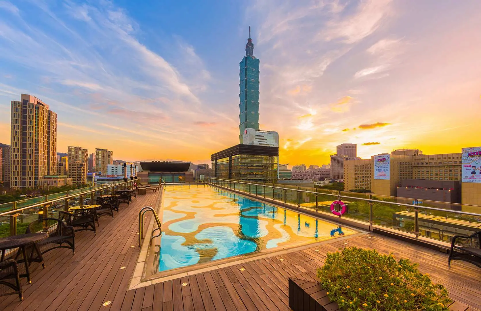 台北艾麗希爾頓格芮精選酒店屋頂泳池在夕陽餘暉下的景色，搭配台北101的壯麗背景，提供獨一無二的跨年體驗。